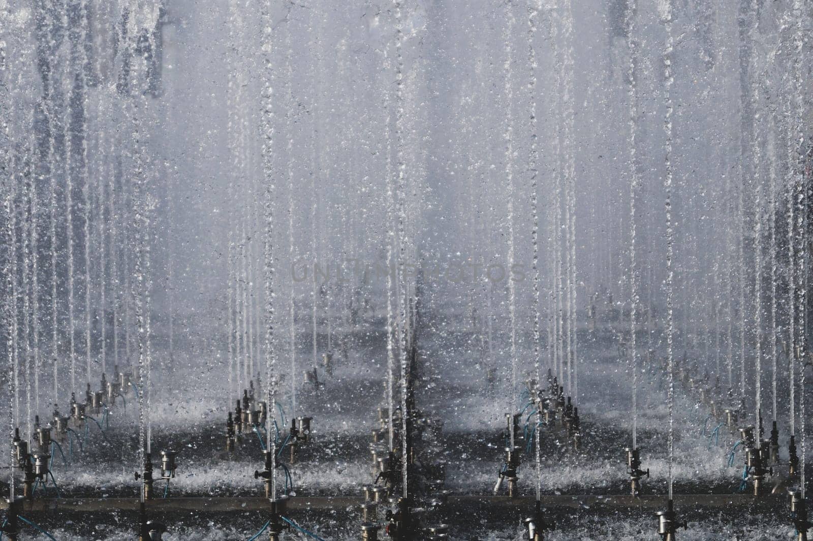 High fountain spraying water in the park. fountain spray system close up