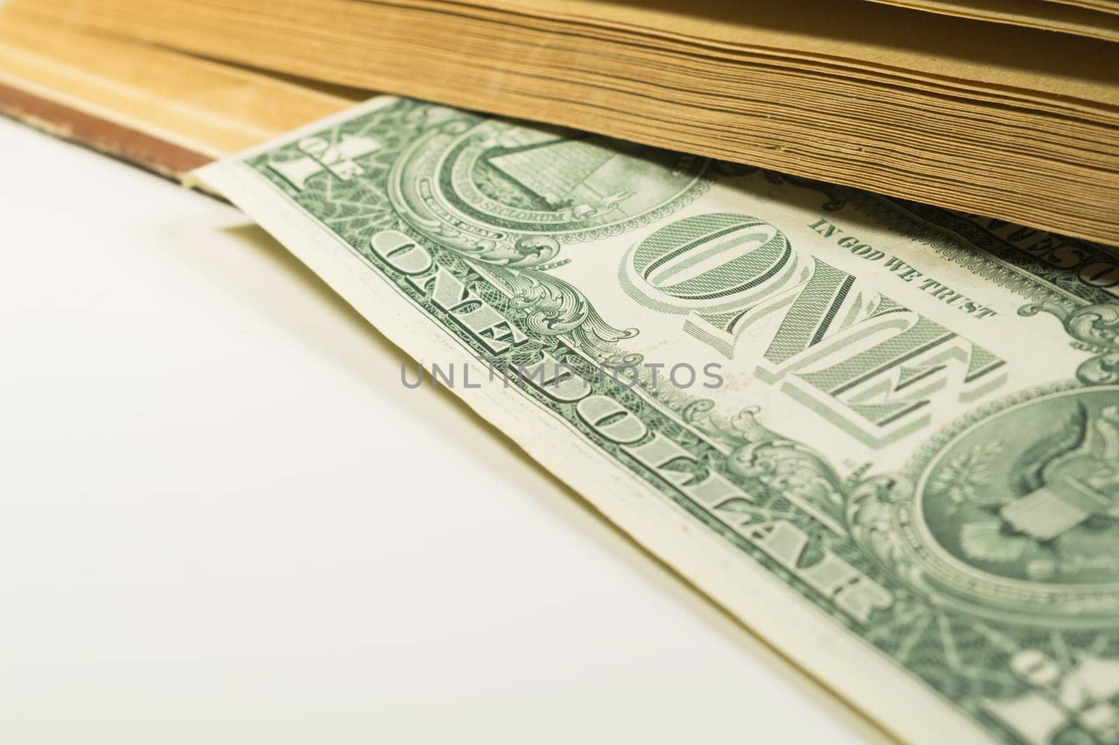 Money in a book. dollar bill used as a bookmark in the book on a white background. copy space