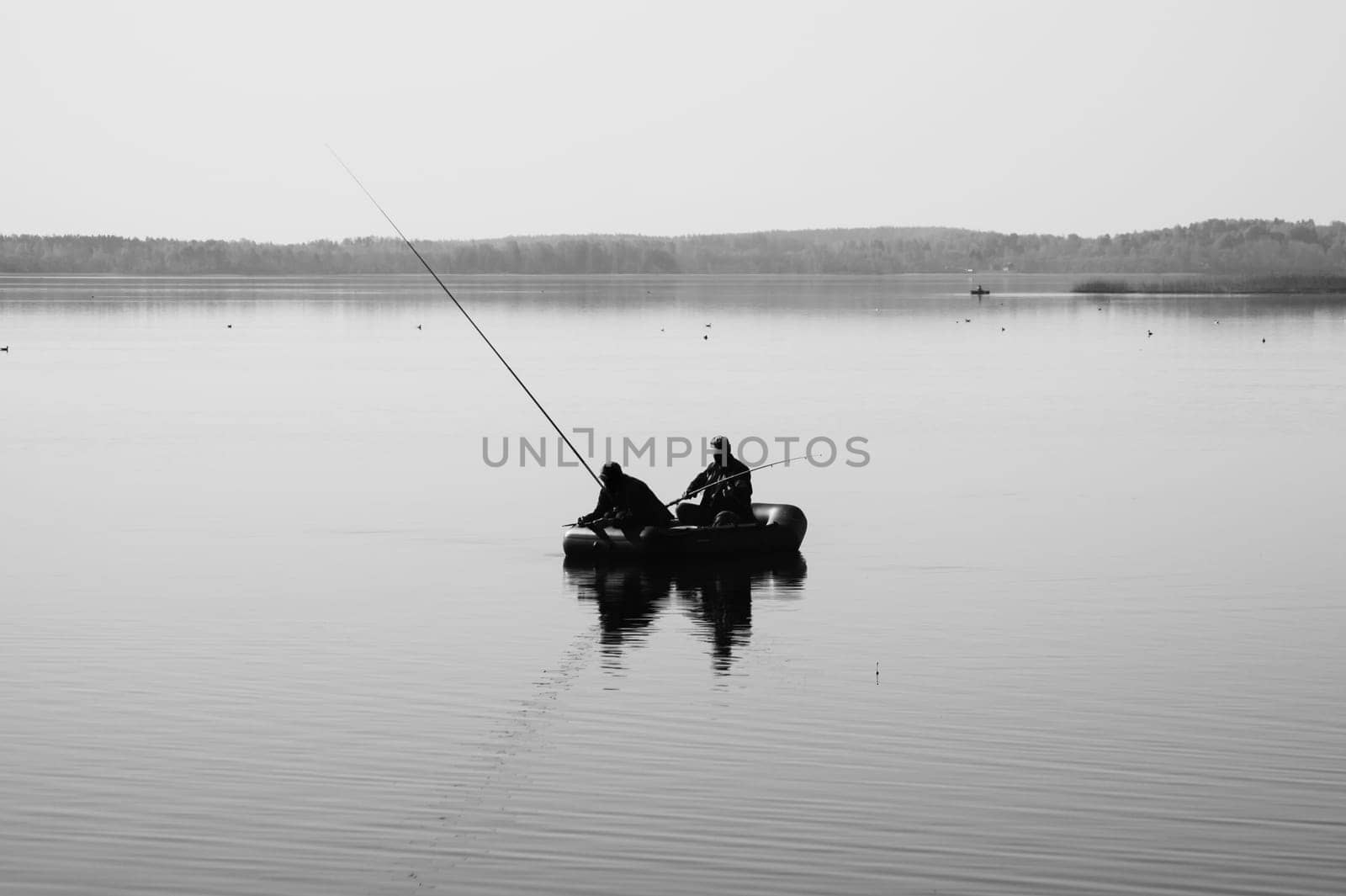 Fishermen catching fish. silhouette of fishers on a fishing boat. calm background