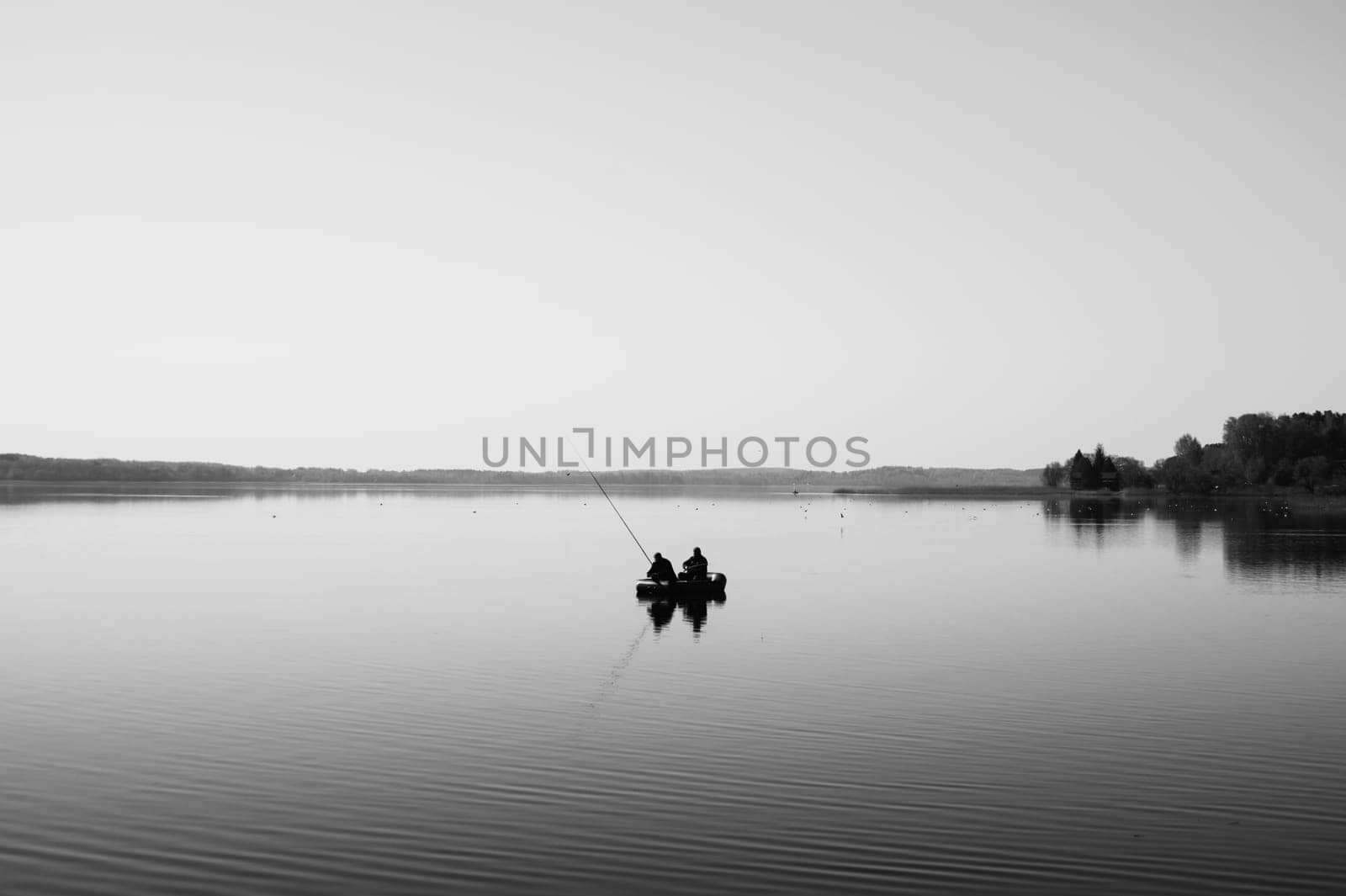 Fishermen catching fish. silhouette of fishers on a fishing boat. calm background