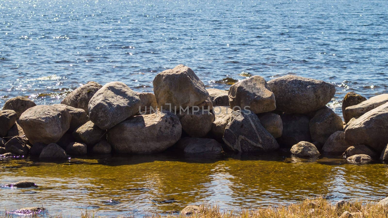 Dam from stones. dyke made from natural materials. pile of rocks in the water