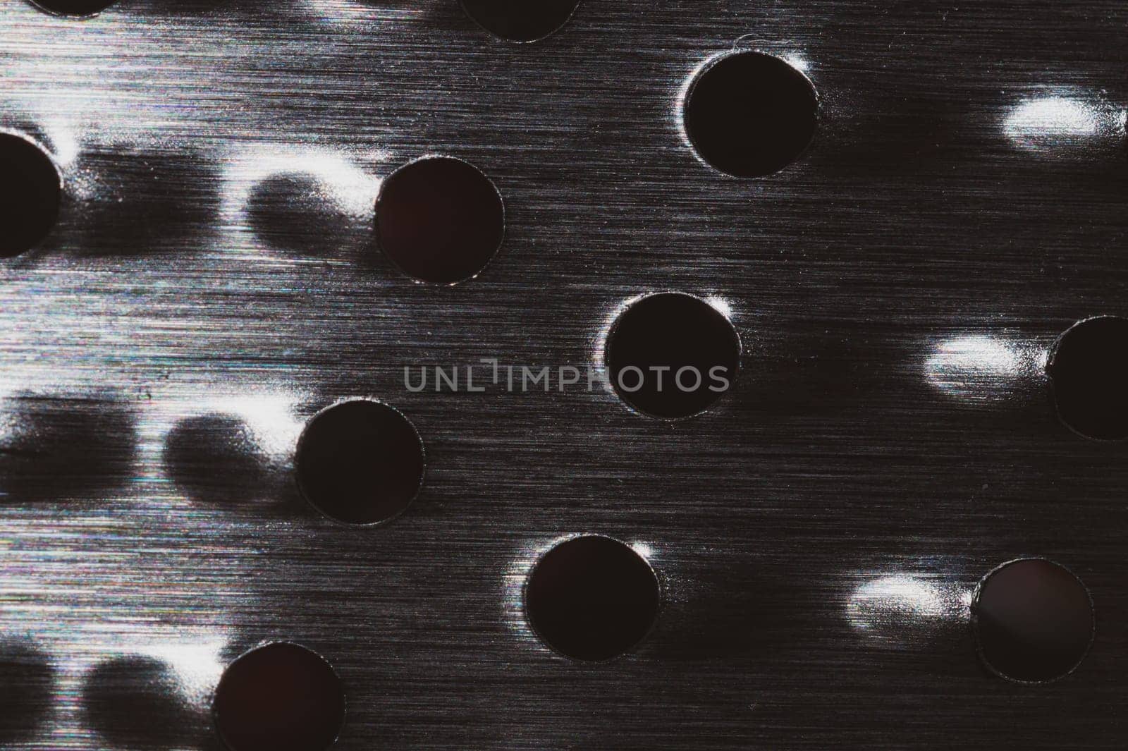 Grater with holes close up background. metal grid with round cell