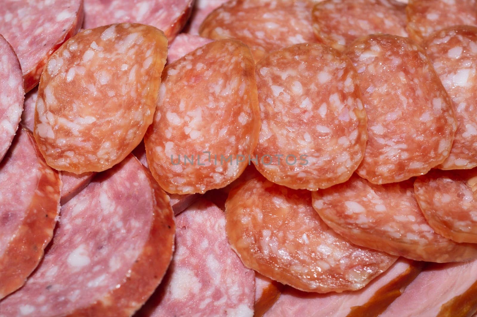Salami background. many sliced pieces of sausage