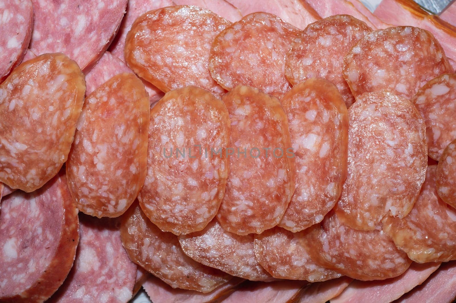 Salami background. many sliced pieces of sausage