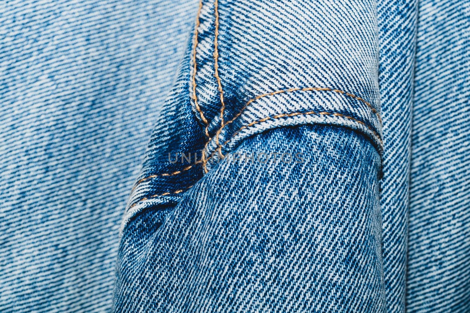 Jeans background with seams. denim texture close up. fabric backdrop with stitches