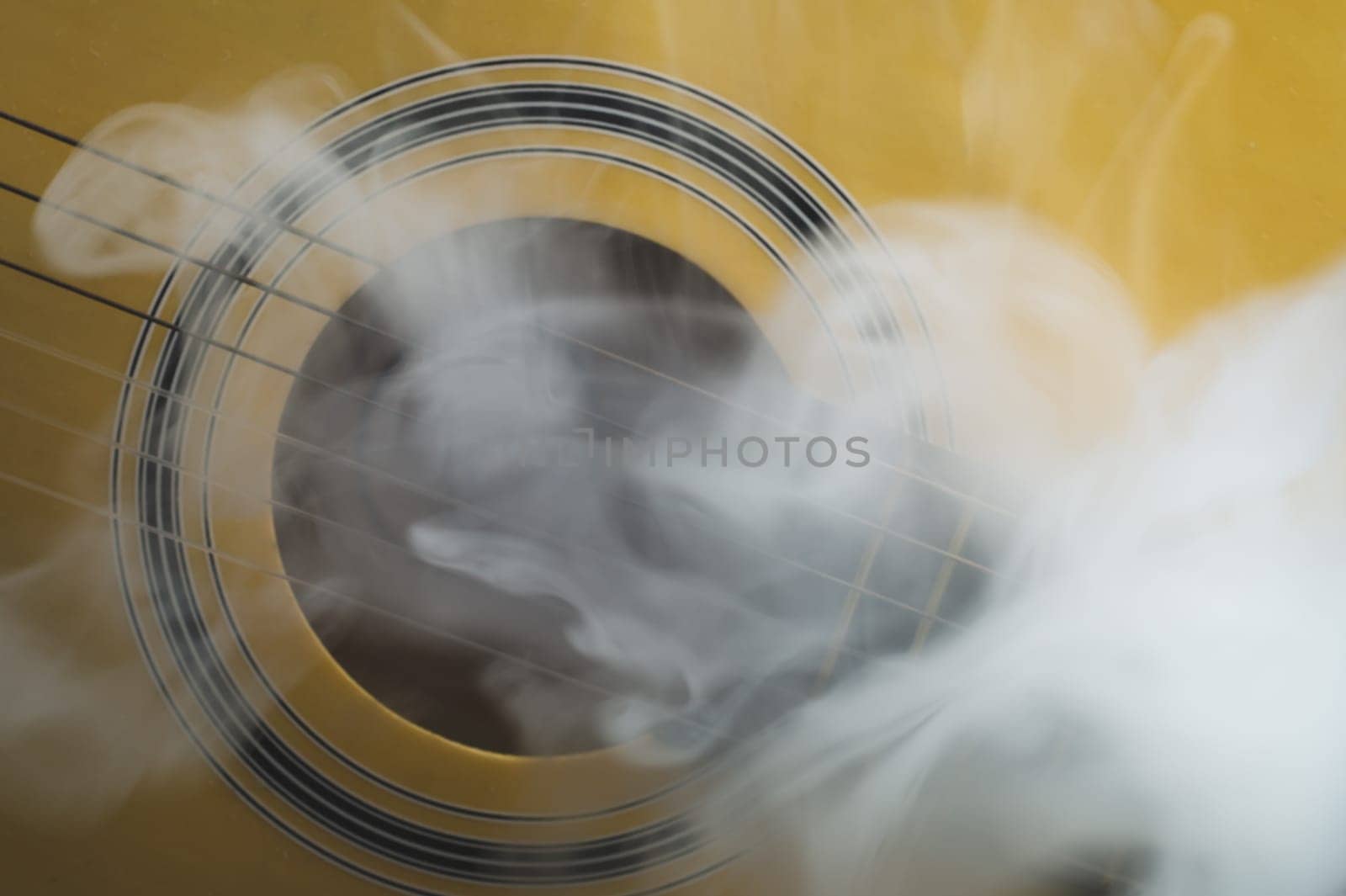 Guitar in smoke close up. acoustic musical instrument. strings on the guitar