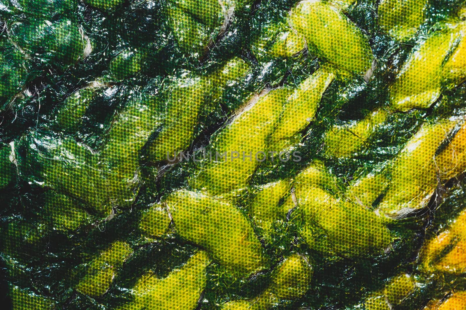 Green material close up background. creased cloth abstract texture