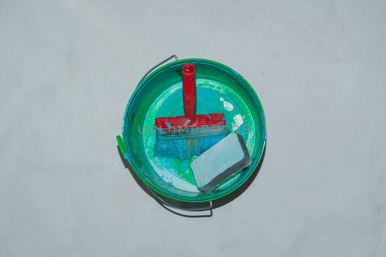 Empty paint bucket with used brush. process of renovation