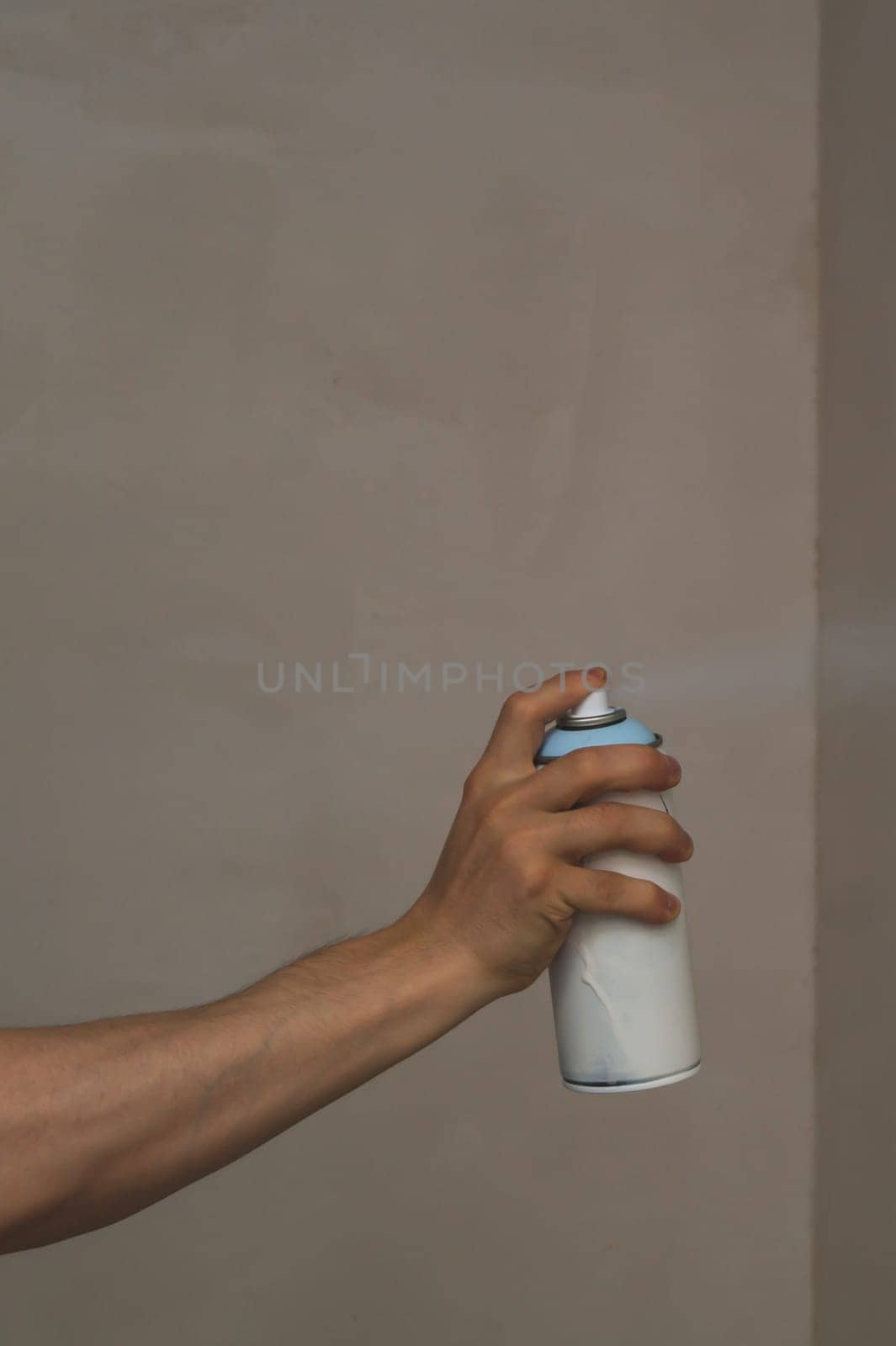 Spray can in the hand. spraying paint on the wall. painting process