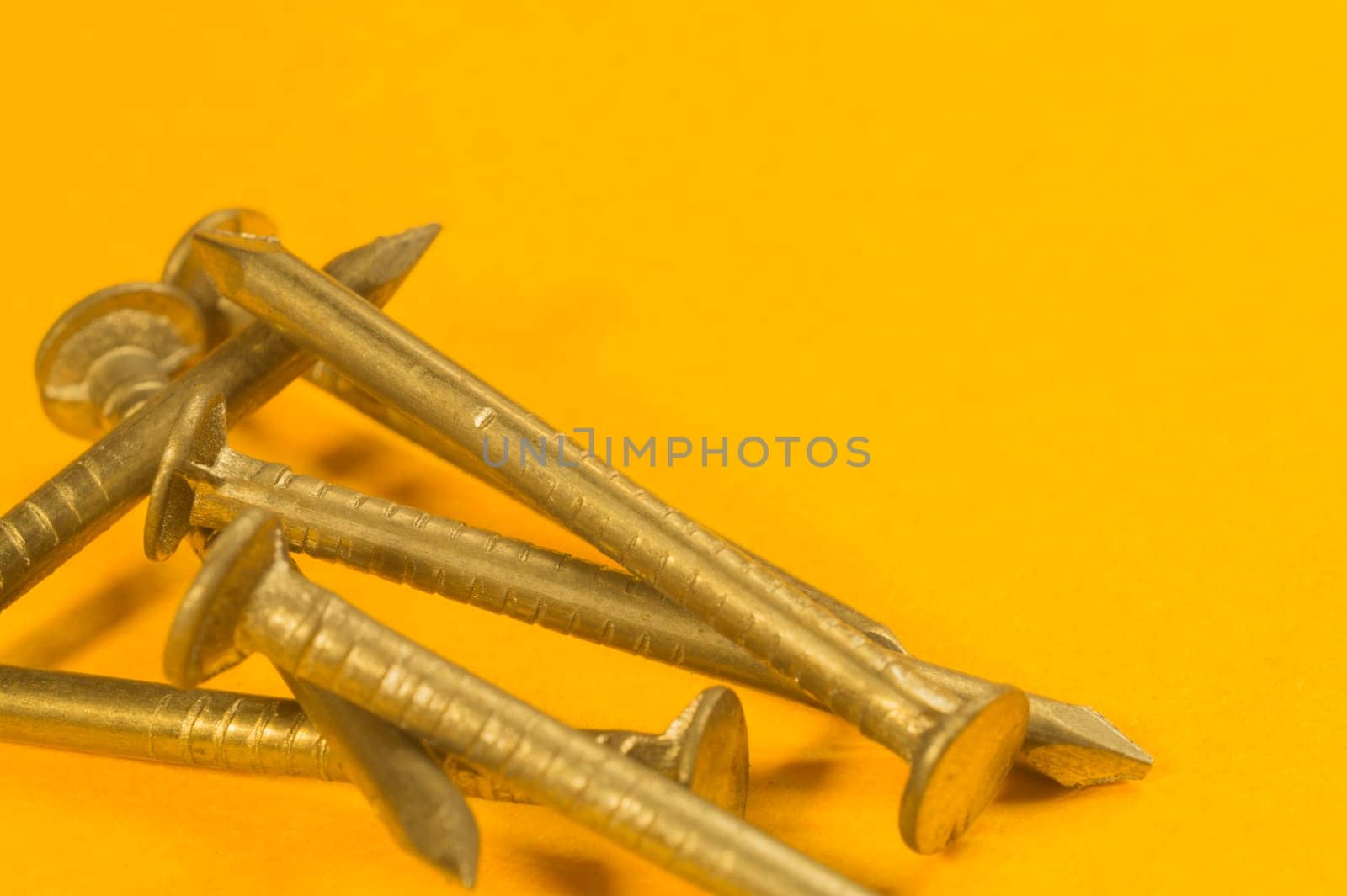 Steel screw on a yellow background. working tools