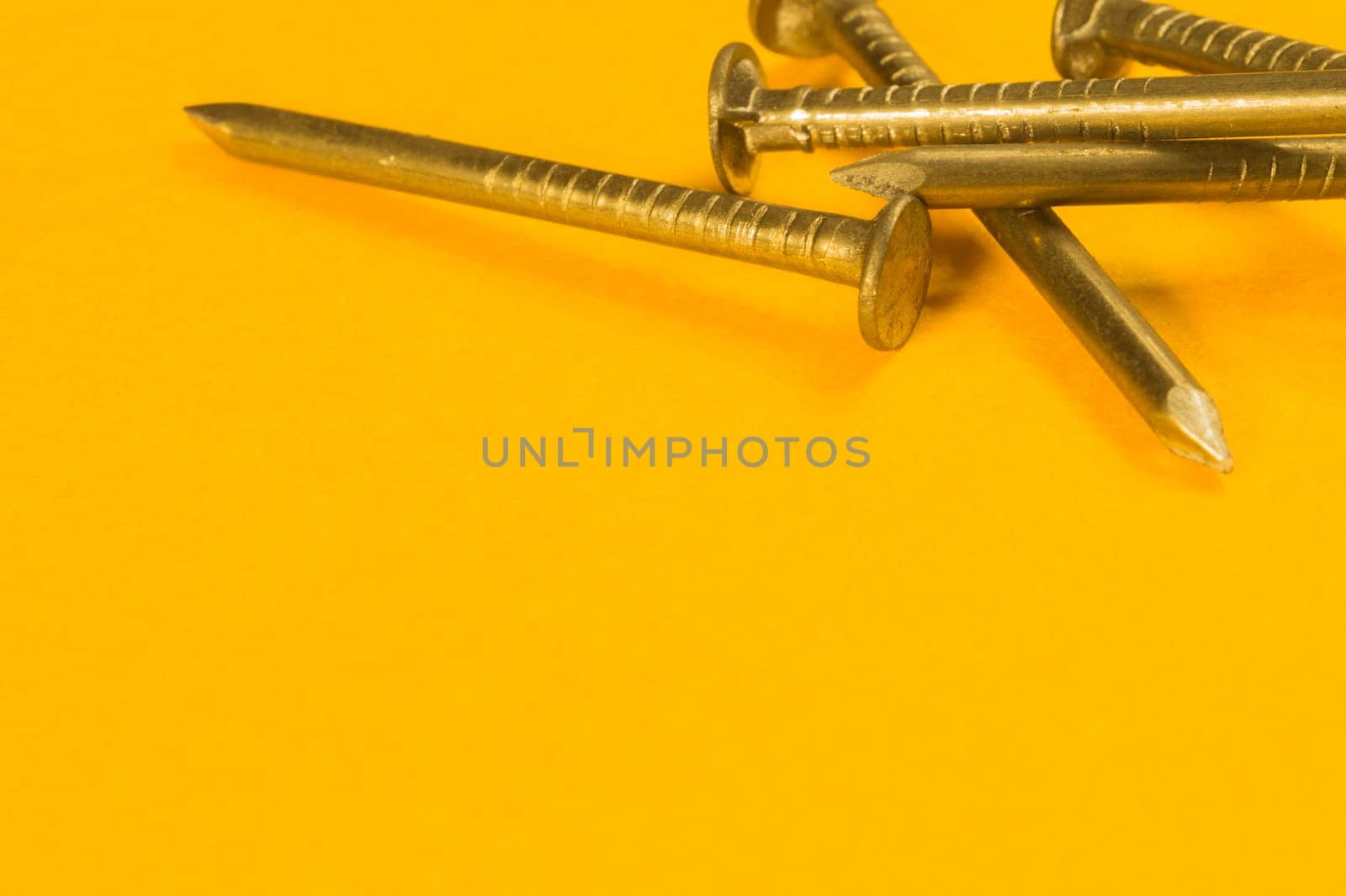 Steel screw on a yellow background. working tools