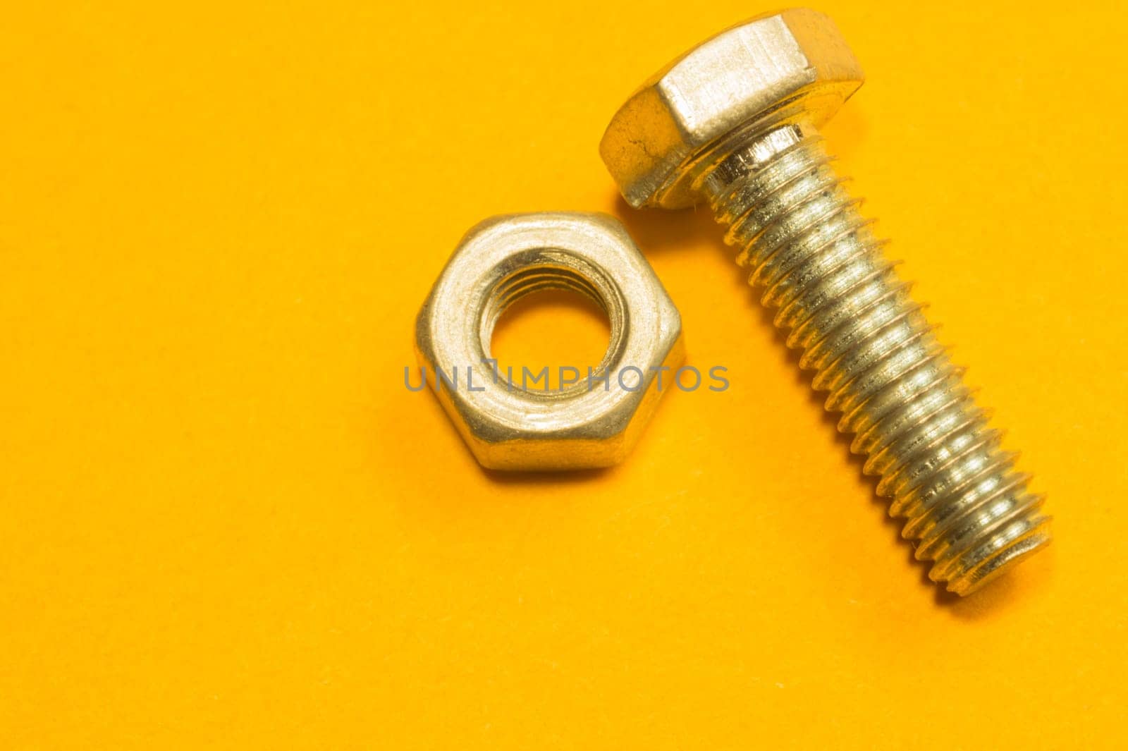 Steel screw on a yellow background. working tools