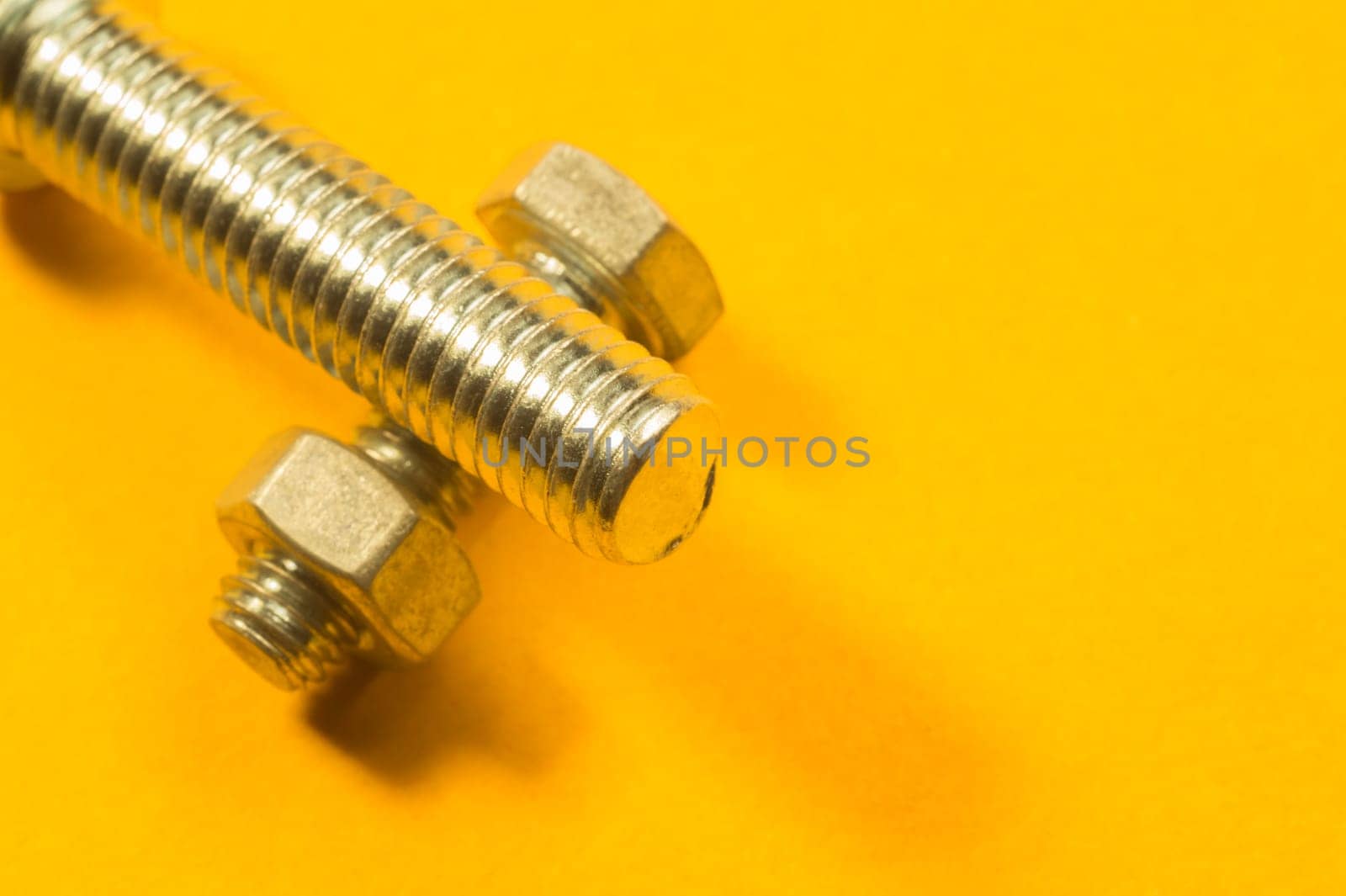 Steel screw on a yellow background. working tools