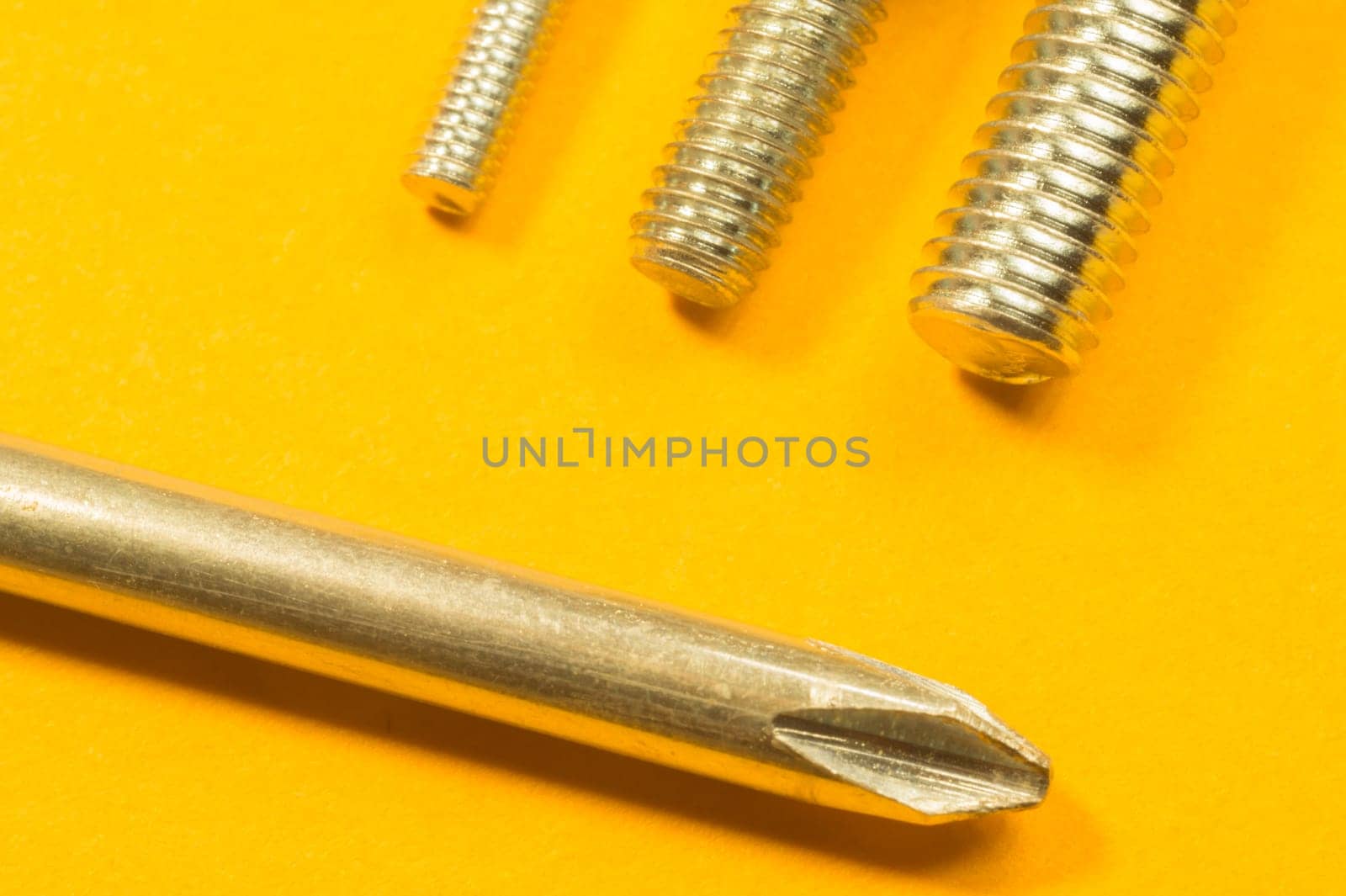 Steel screw on a yellow background. working tools