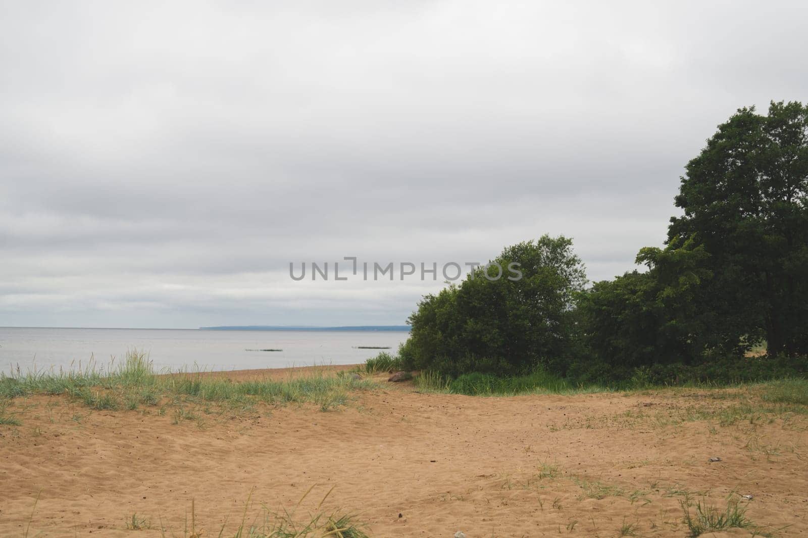 Sand beach in the bay under cloudy sky
