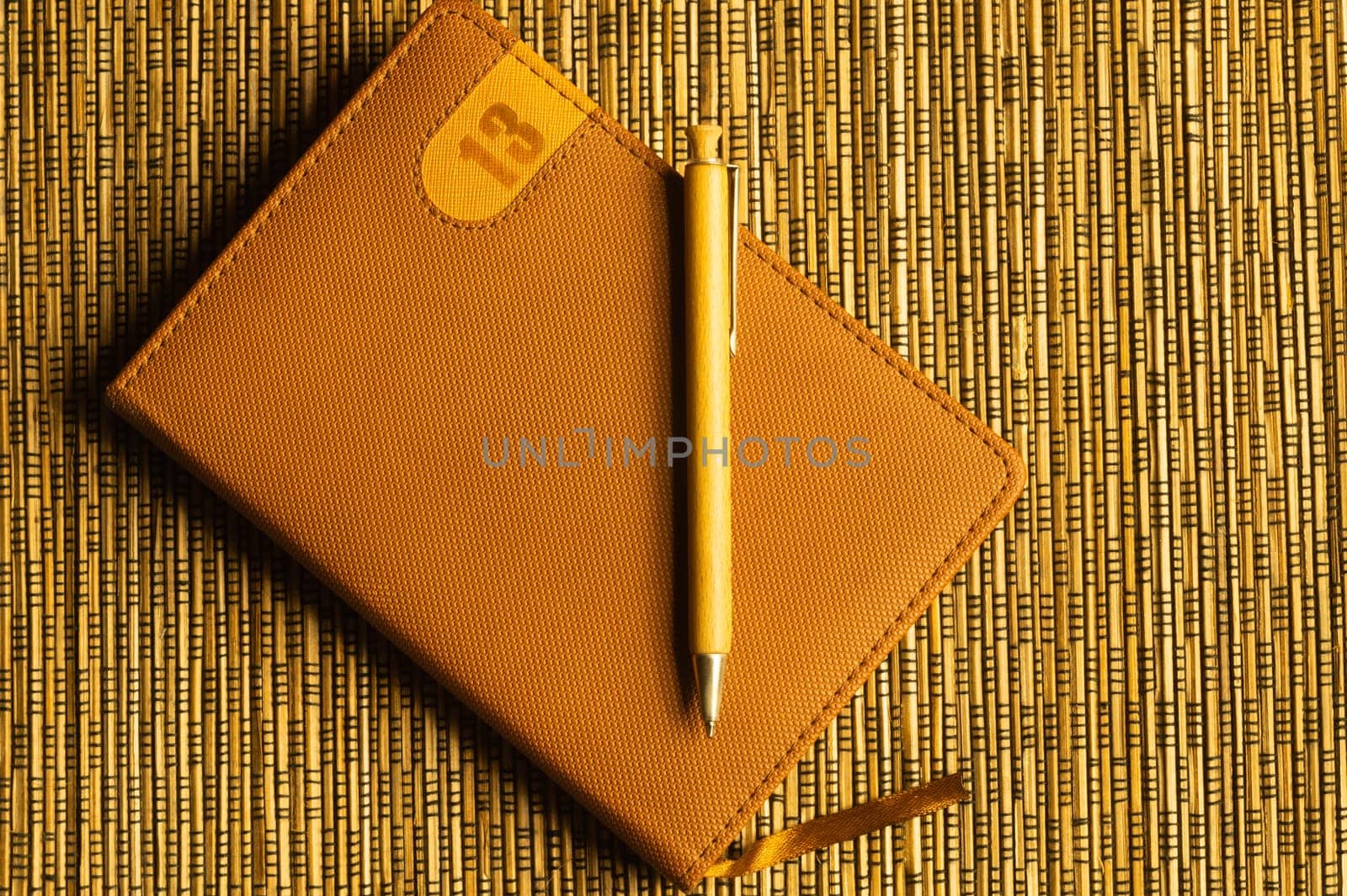 Diary and pen on a wooden bamboo background. notebook and pen top view. copy space