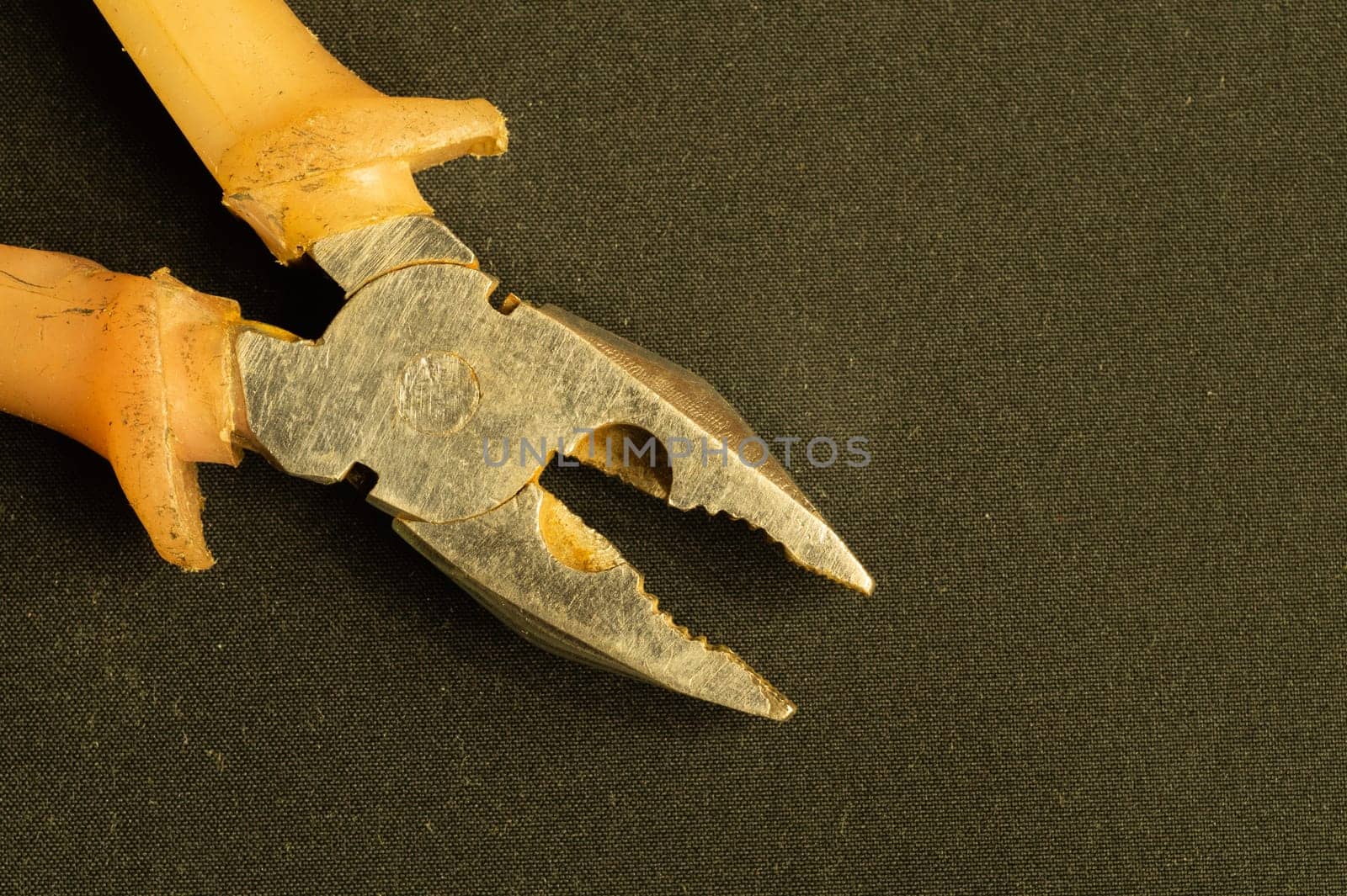Pliers with orange handles on black background. work tool. copy space