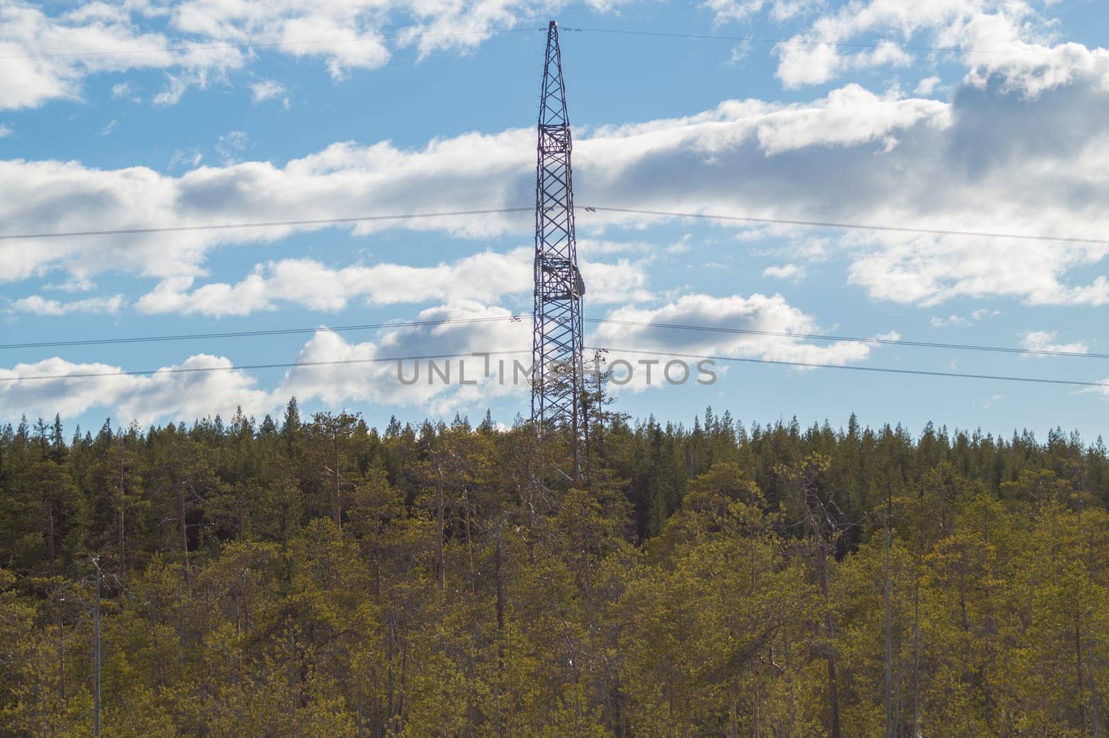 Power line post in forest. high voltage tower with the sky. industrial background