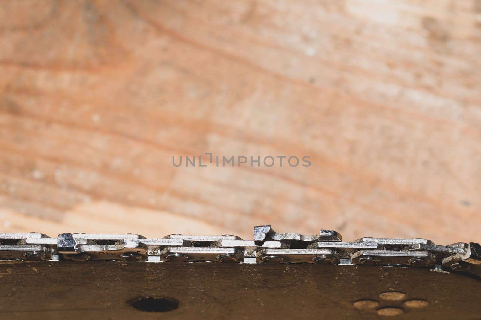 Chainsaw bar and cutting chain close up. blade of a chainsaw on a wooden background. copy space