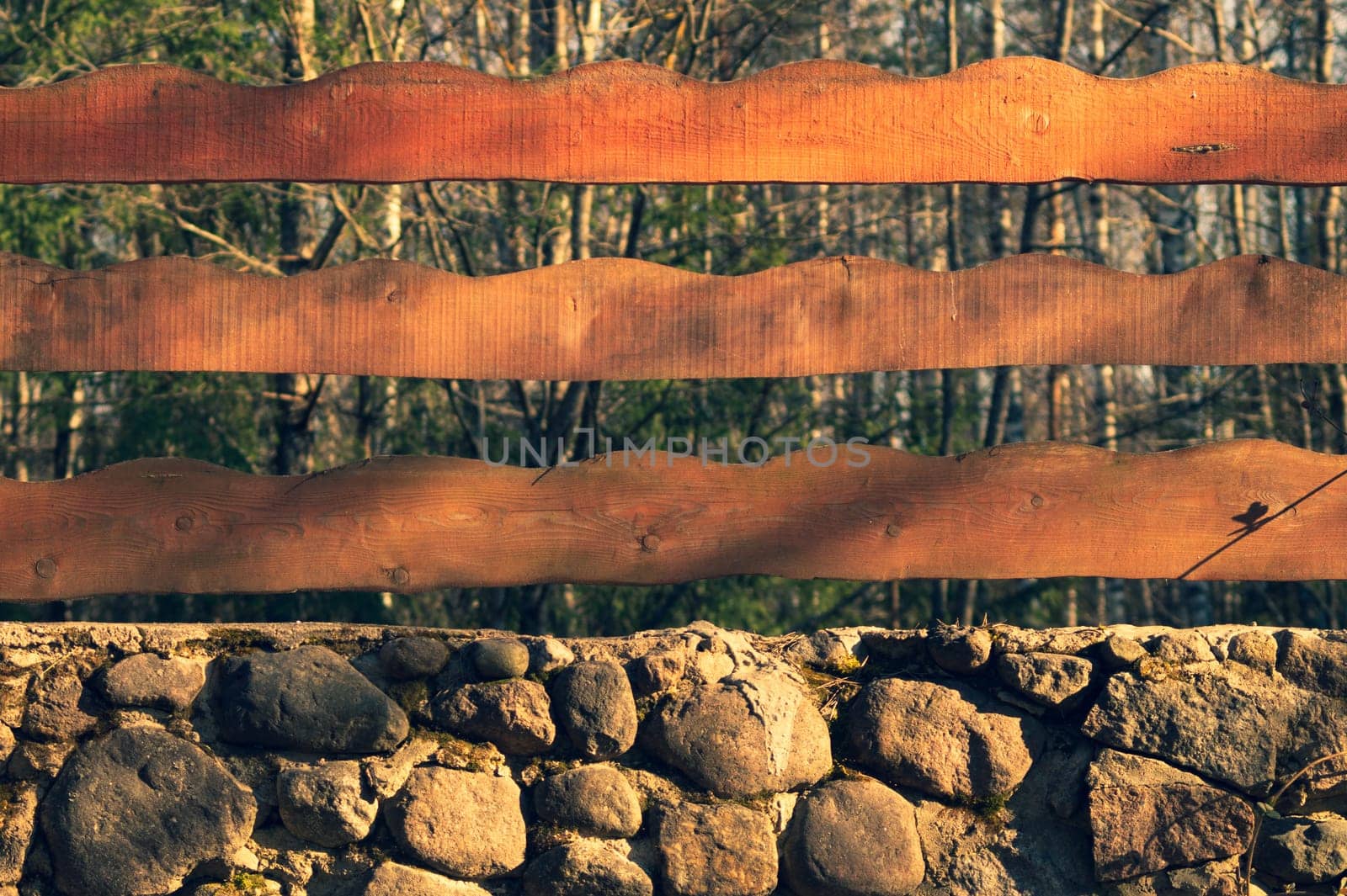 Wood and stone background. wooden fencing and natural stone wall in the park