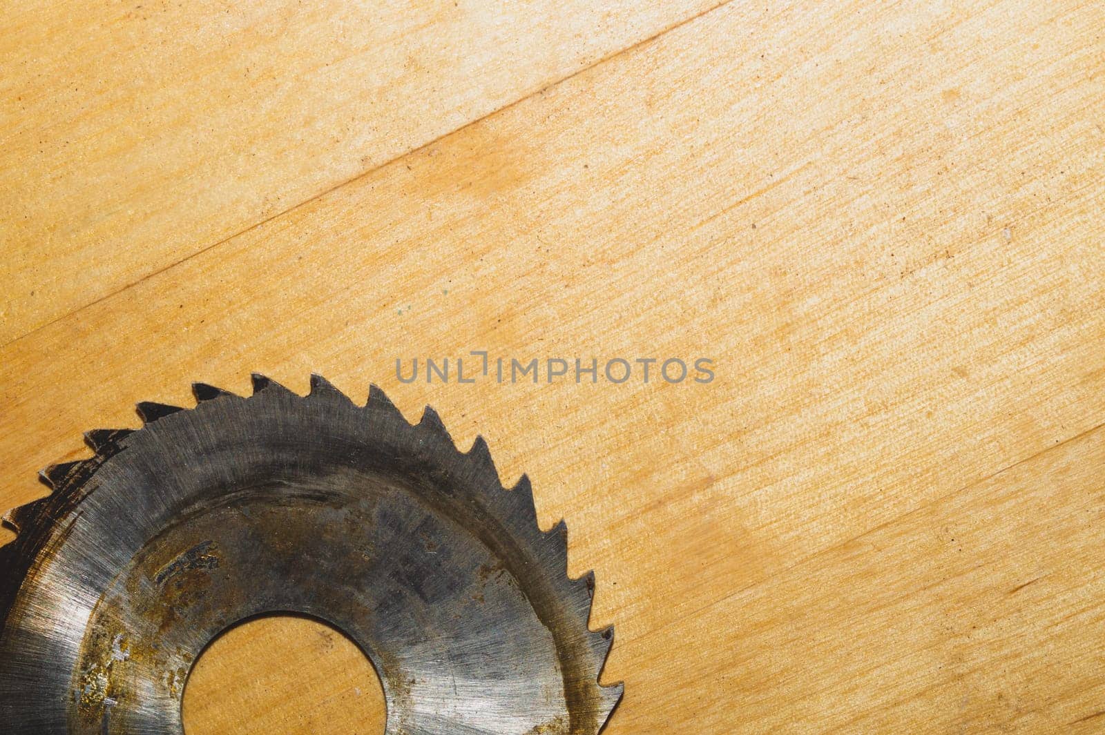 Metal circular saw blade on a wooden background. top view. work tool. carpentry instrument. copy space