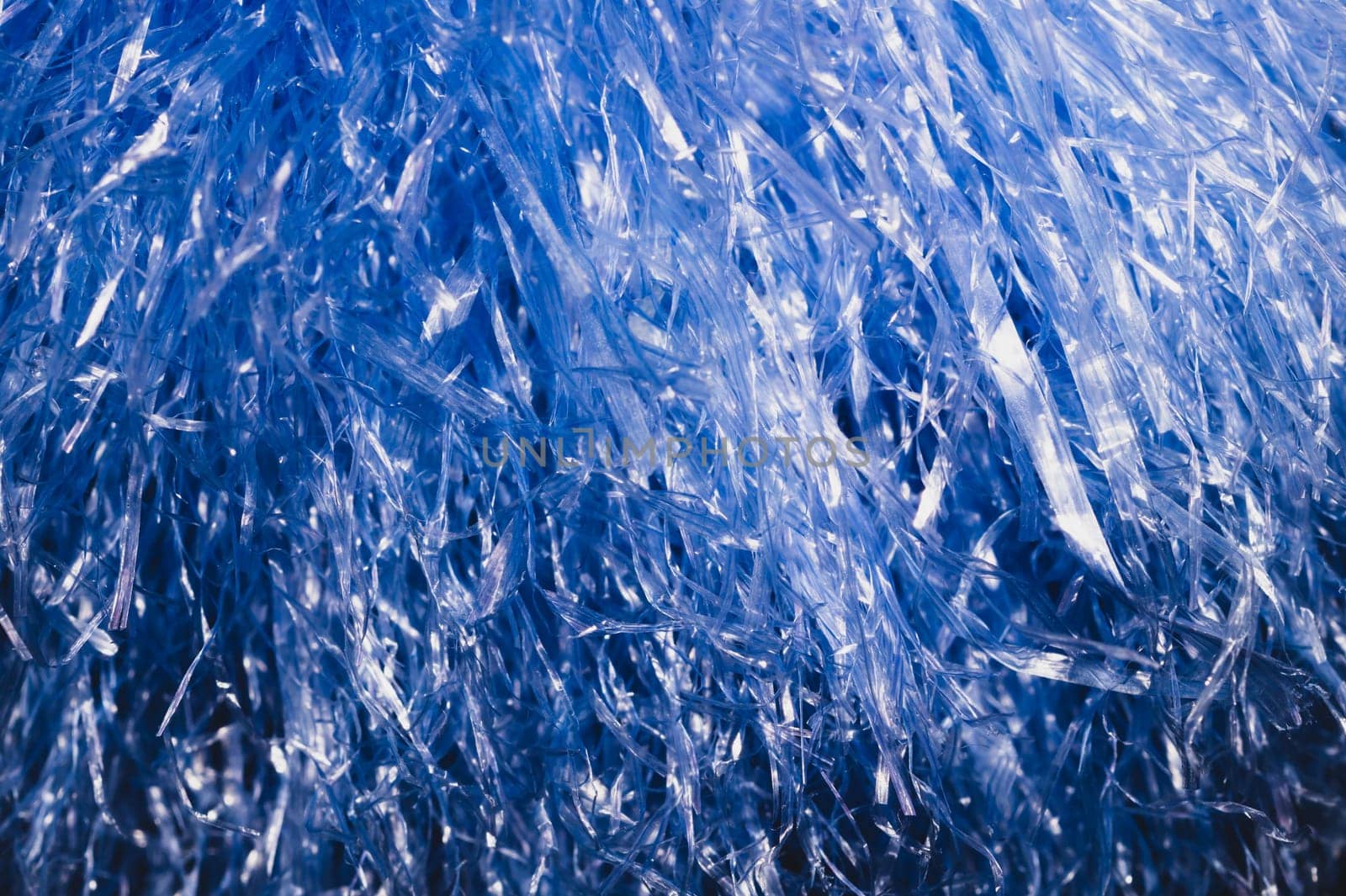 Abstract blue texture with wavy plastic stripes. blue tinsel macro
