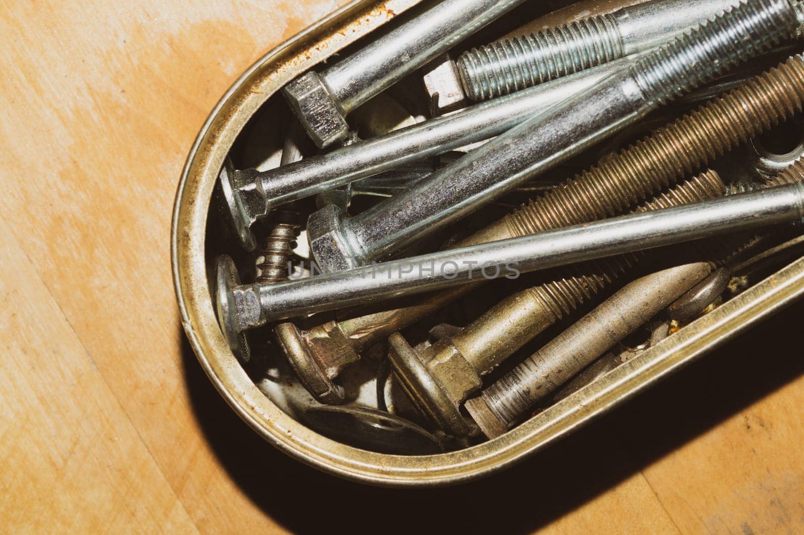 Old screws in a box. a lot of various screws. pile of fasteners in the box close up. carpentry workshop. work tool