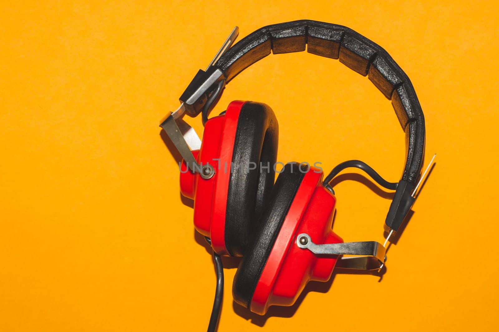 Vintage red headphones on yellow background. retro earphones