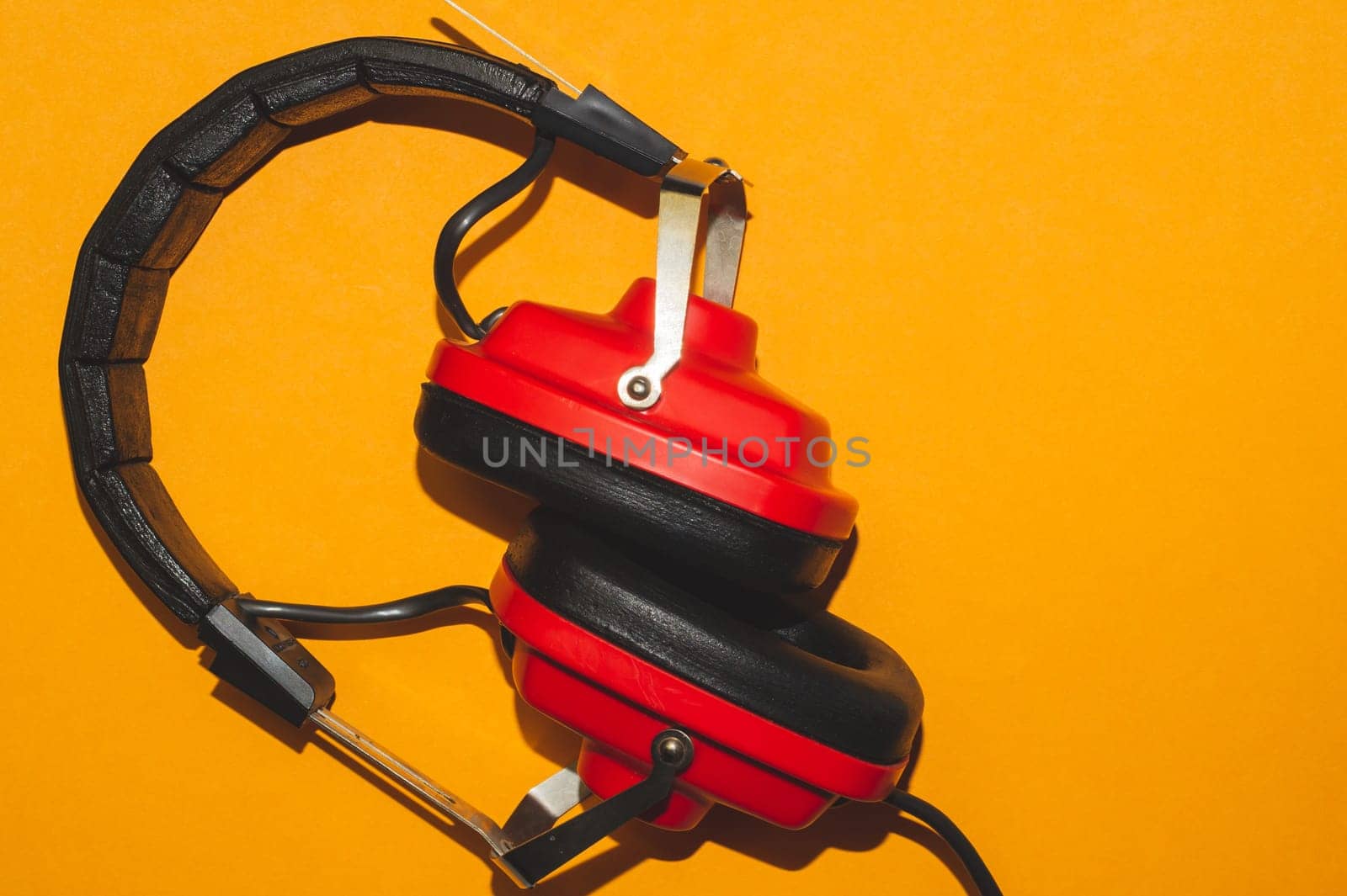 Vintage red headphones on yellow background. retro earphones