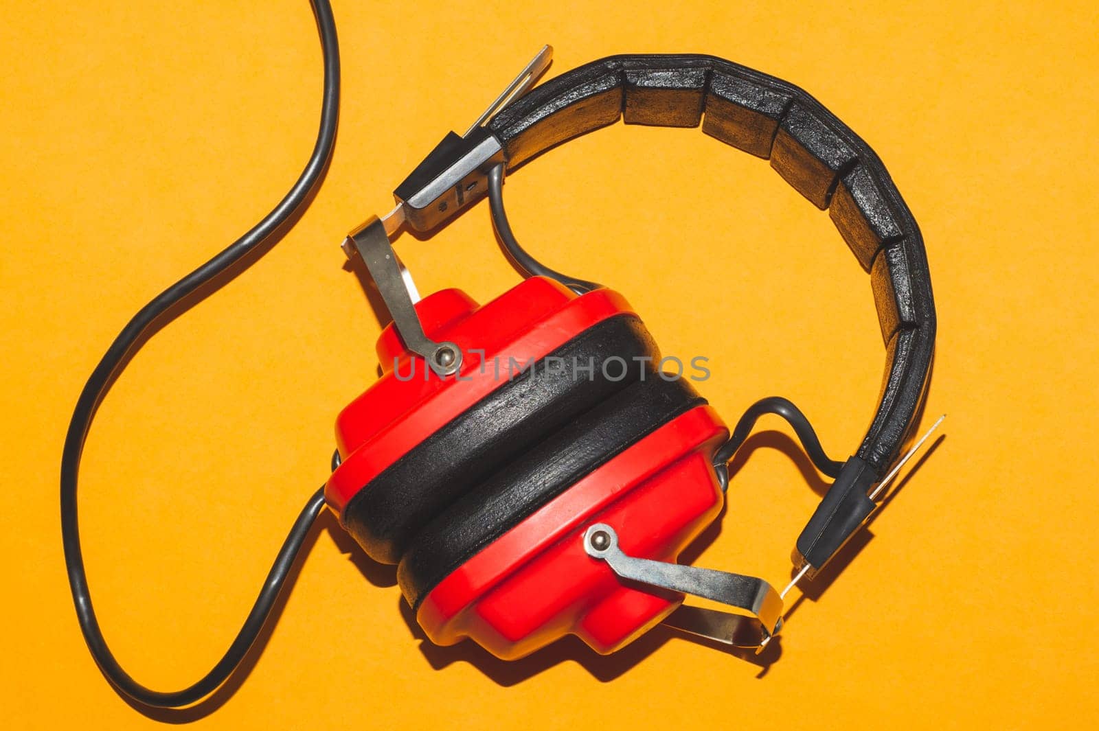 Vintage red headphones on yellow background. retro earphones