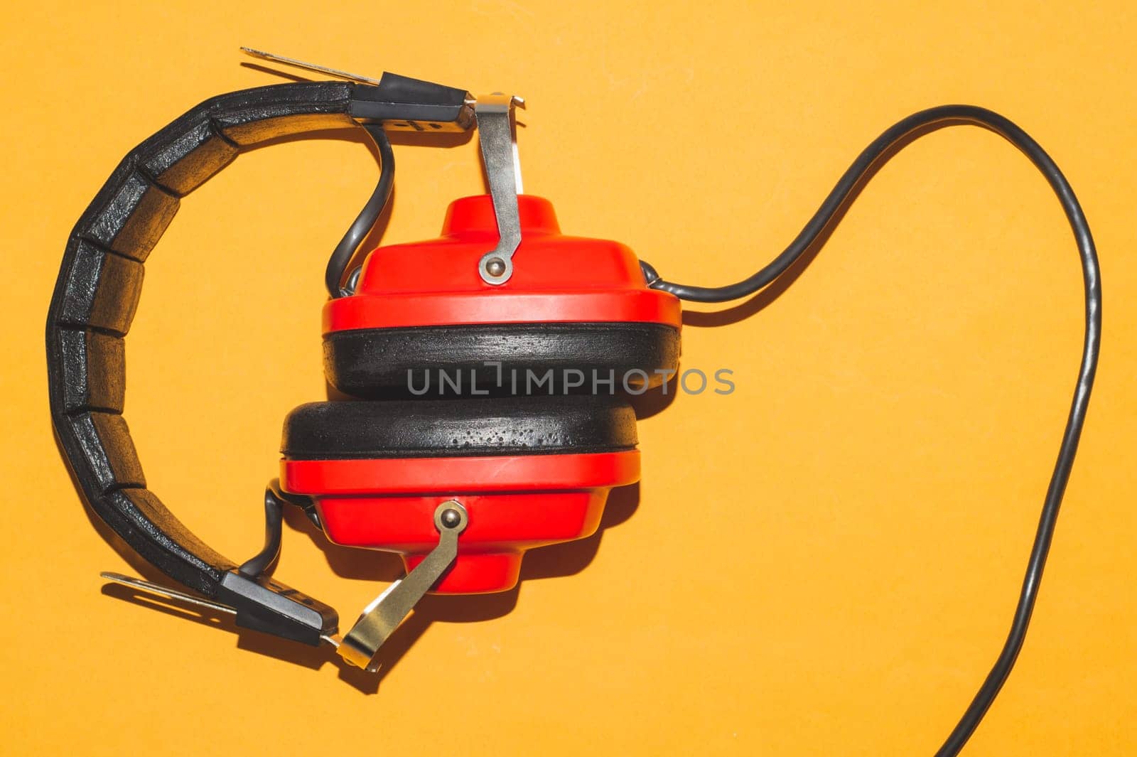 Vintage red headphones on yellow background. retro earphones