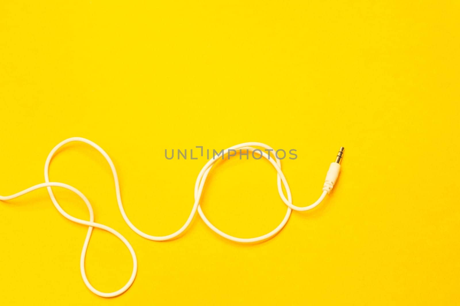 Audio jack with white cable isolated on yellow background