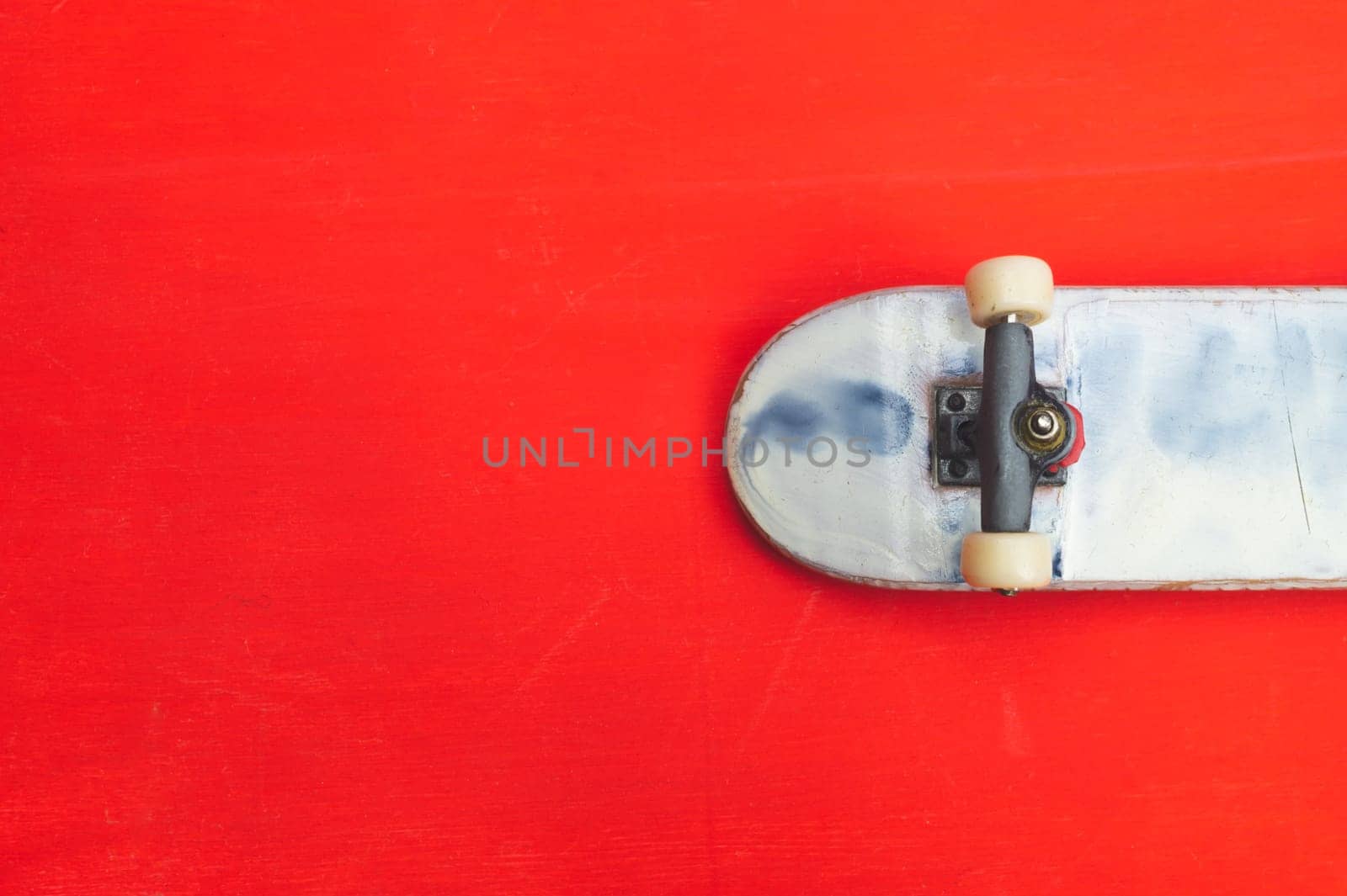 Small skateboard on red background. tiny skate for fingers. fingerboard close up. copy space