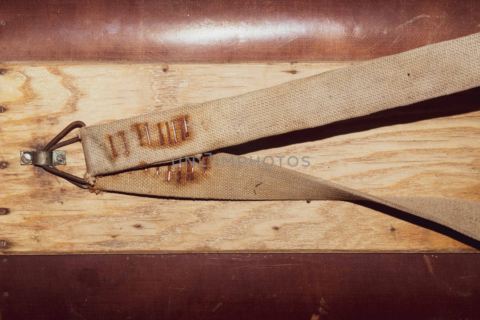 Wooden surface with nailed straps. side of wooden box with belts for carrying