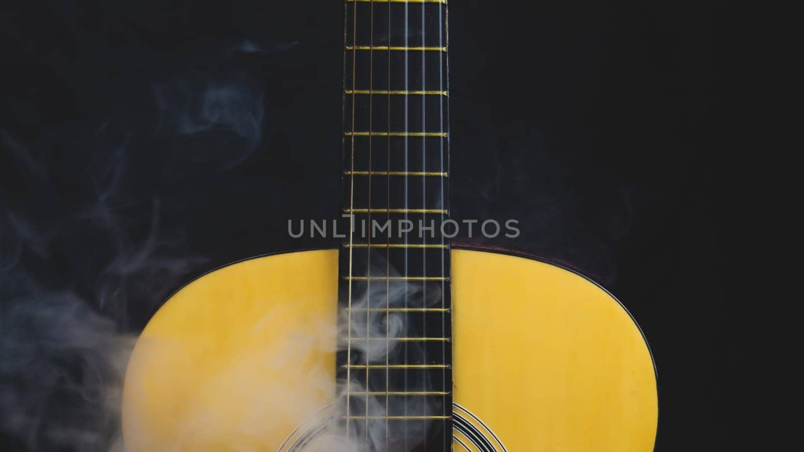 Guitar in smoke close up. musical instrument. strings on the guitar neck