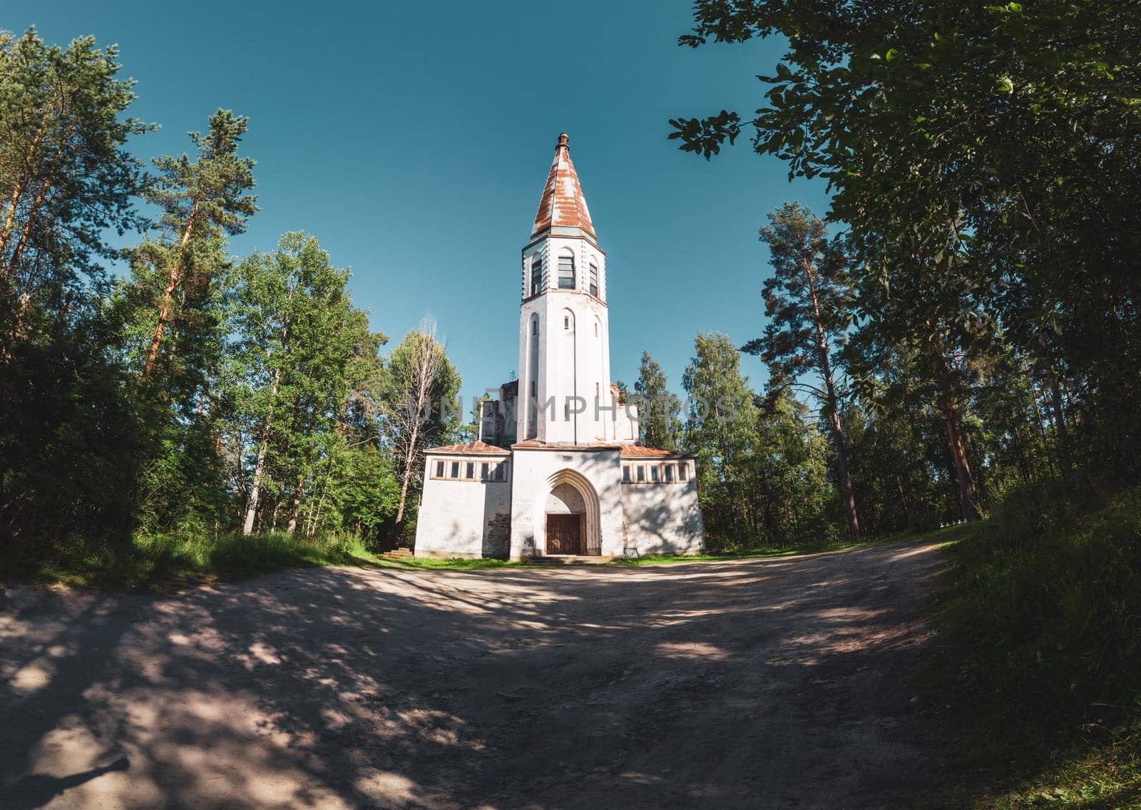 Old wooden church among the overgrown field. rural panoramic landscape. roof of ancient chapel