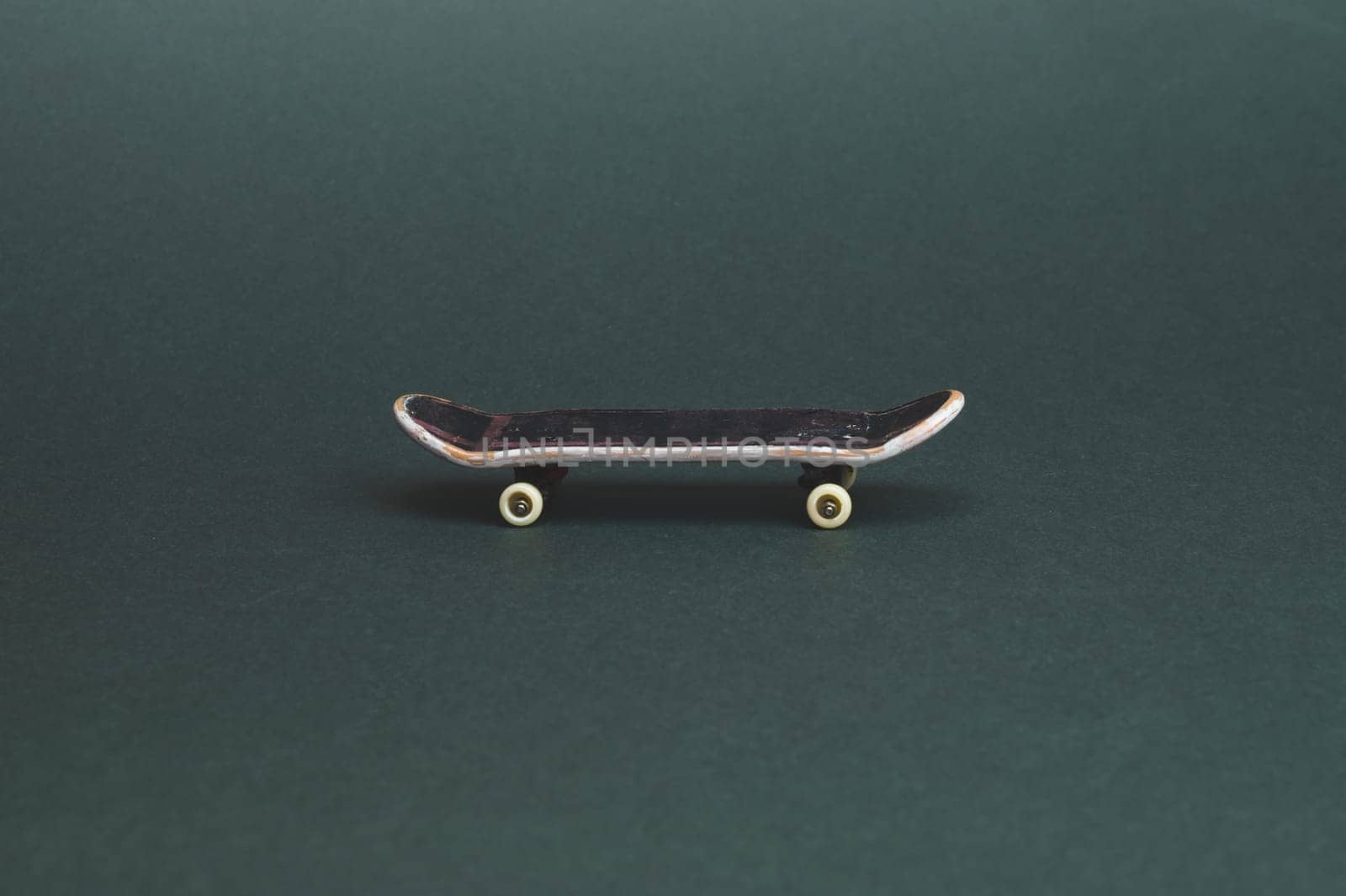 Small skateboard on color background. tiny skate for fingers. fingerboard close up. copy space