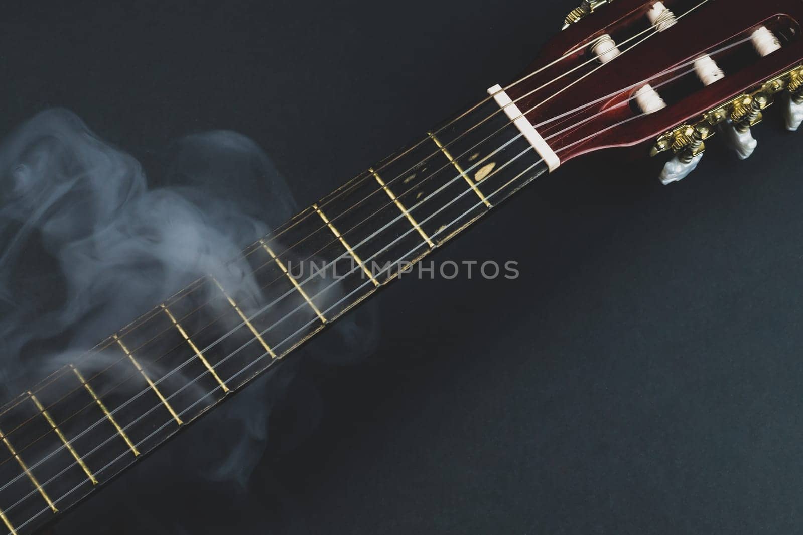 Guitar fretboard in smoke close up. musical instrument. strings on the guitar neck