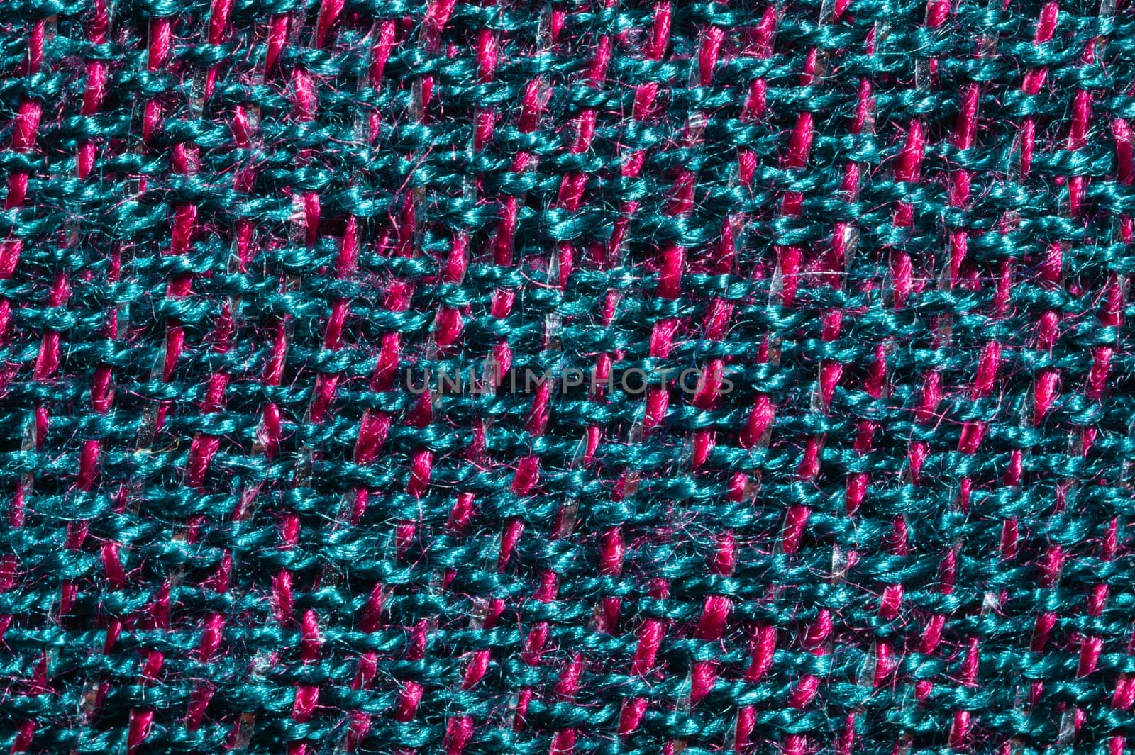 Fabric macro texture. knitted textile. woven background. woolen material. weaving blue and red threads close up