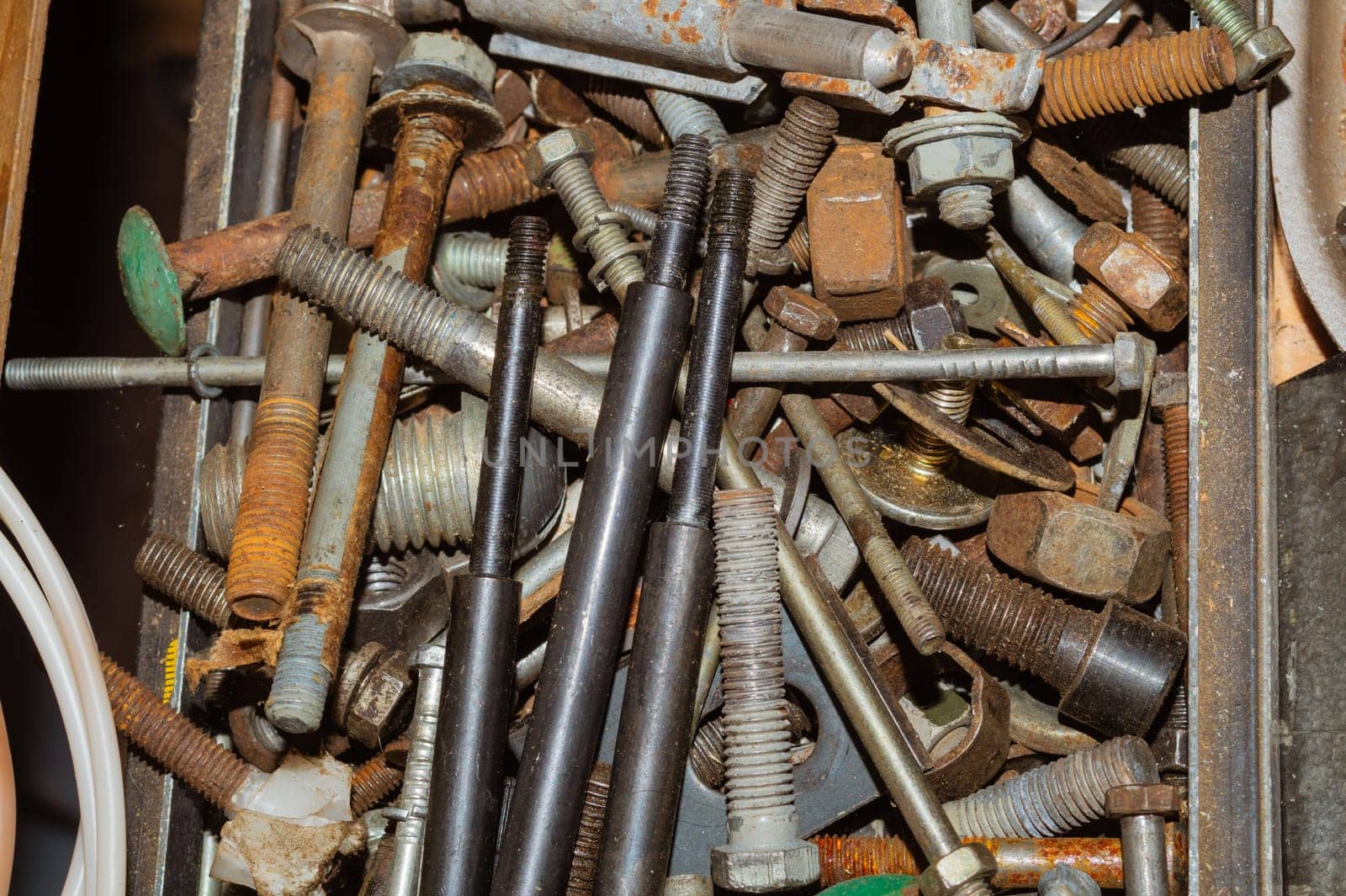 Pile of fasteners and screws close up. scrap metal. different metal parts. industrial background