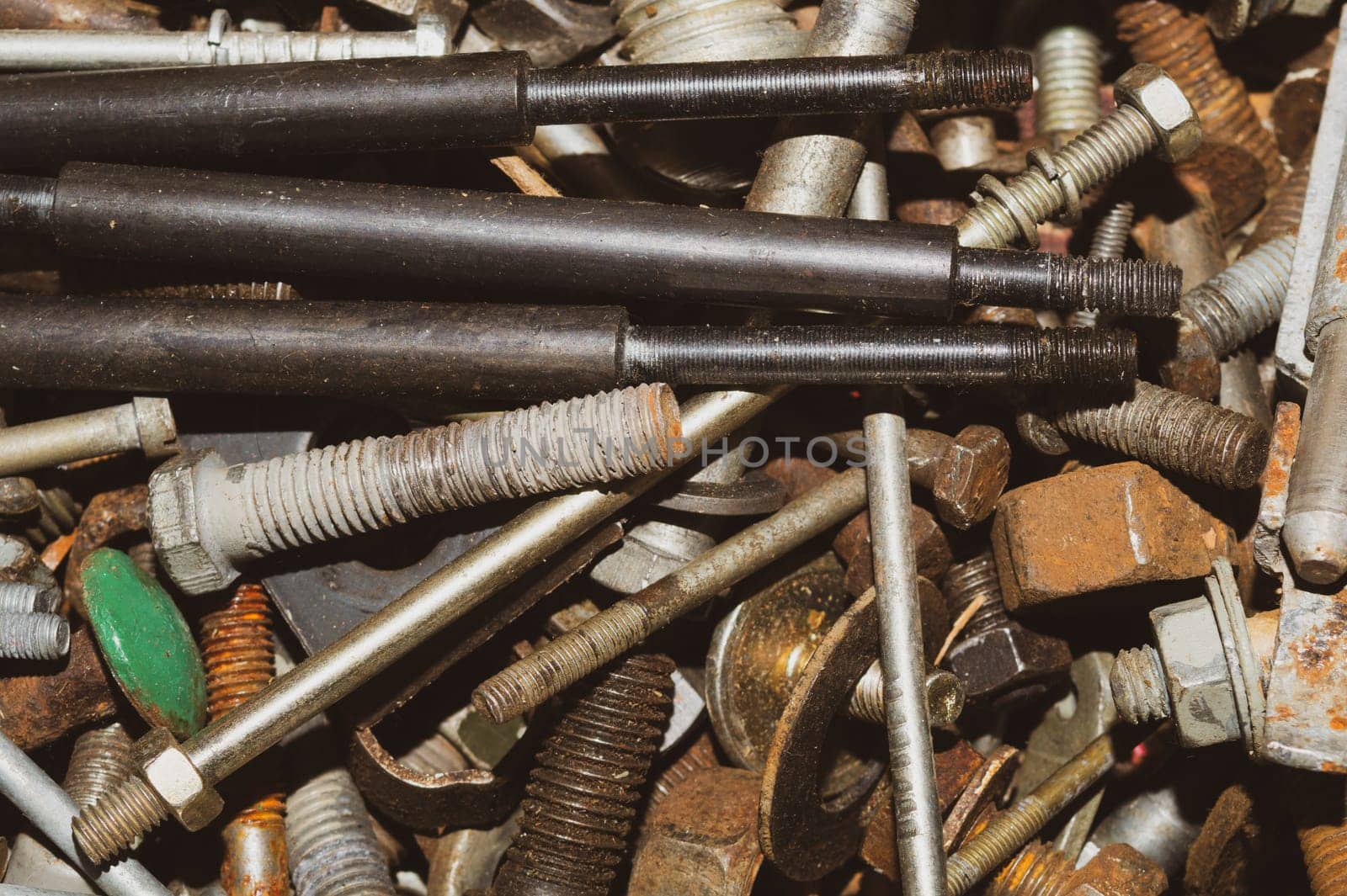 Pile of fasteners and screws close up. scrap metal. different metal parts. industrial background