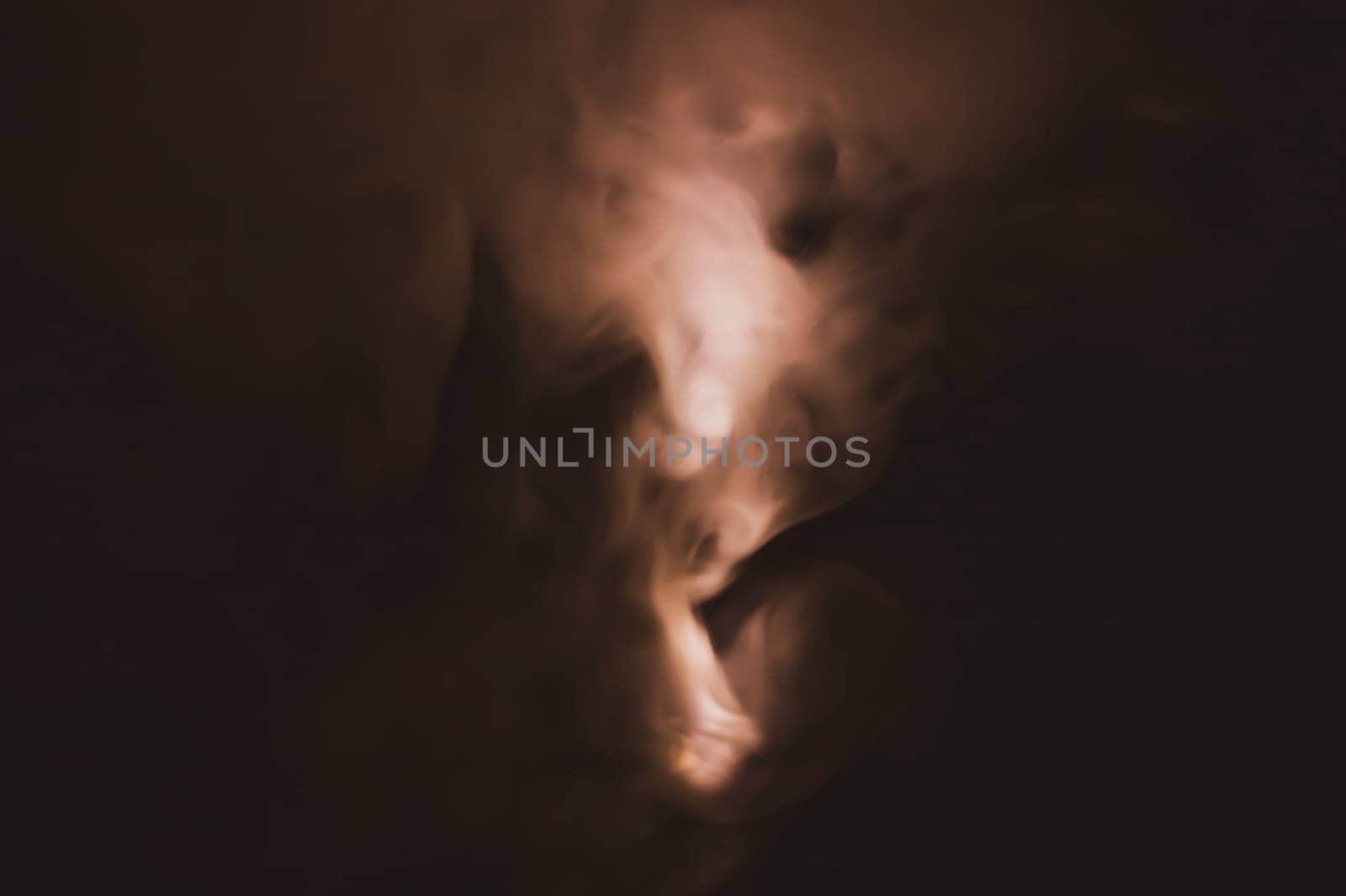 Colored smoke on black backdrop. brown fog abstract background