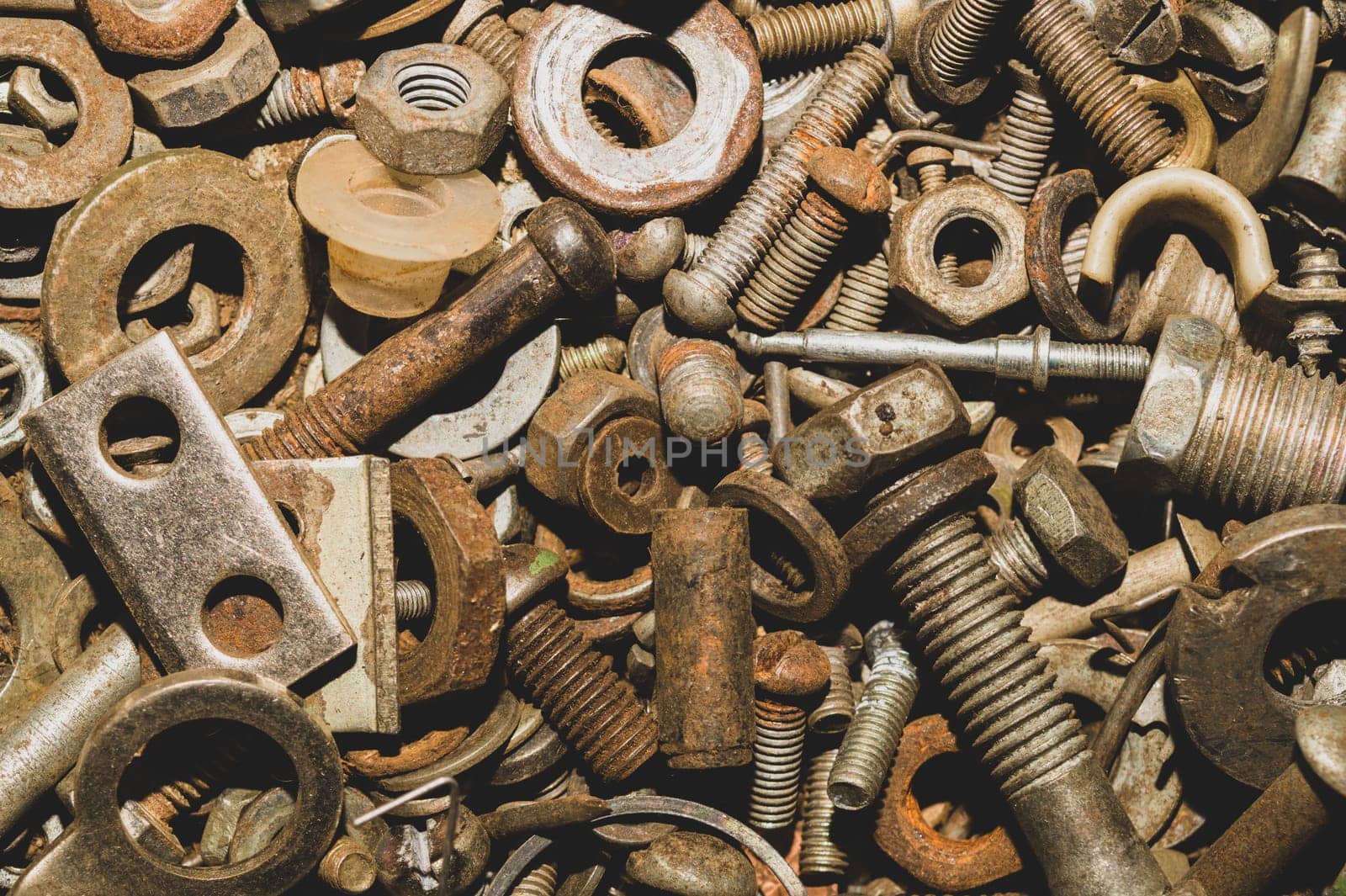 Pile of fasteners and screws close up. scrap metal. different metal parts. industrial background