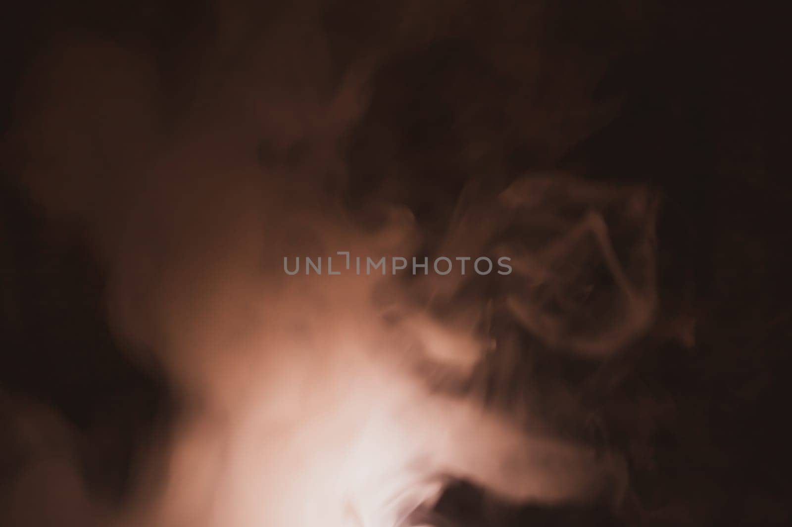 Colored smoke on black backdrop. brown fog abstract background