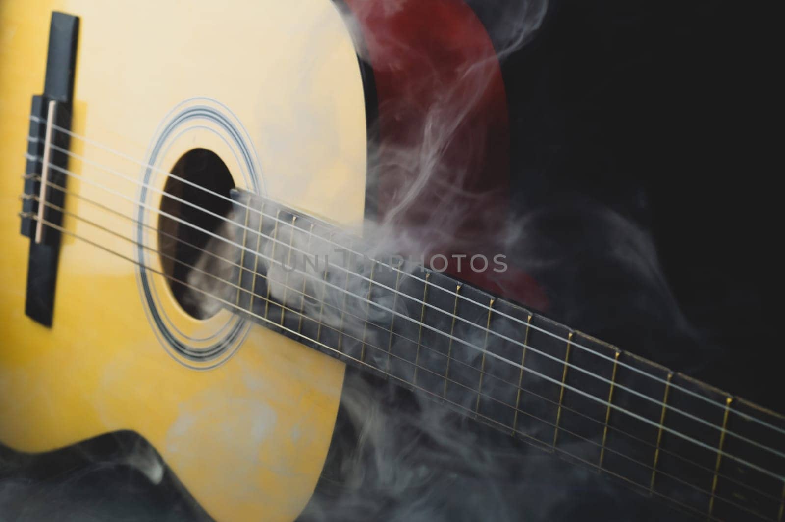 Guitar in smoke close up. musical instrument. strings on the guitar fretboard