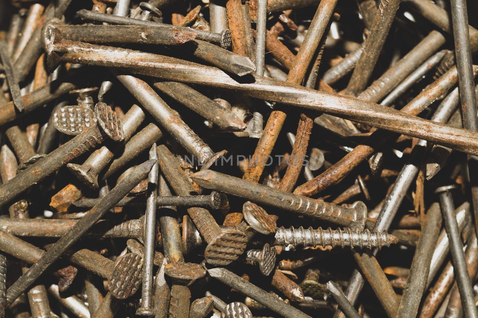 Pile of fasteners and screws close up. scrap metal. different metal parts. industrial background