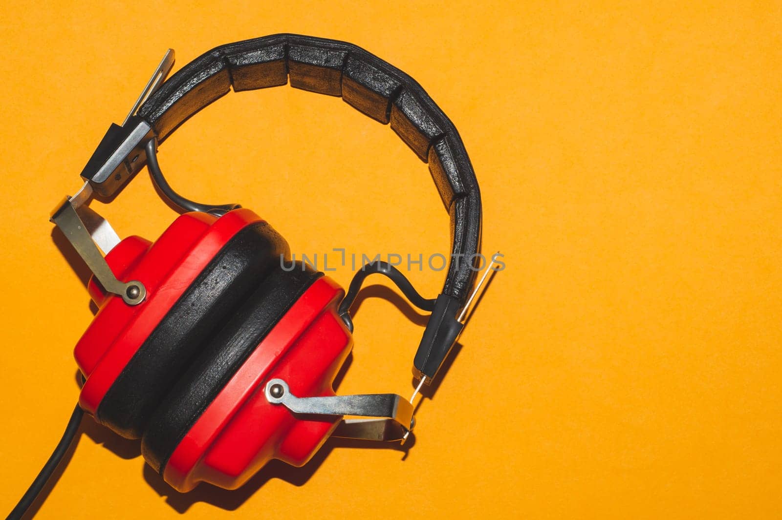 Vintage red headphones on yellow background. retro earphones