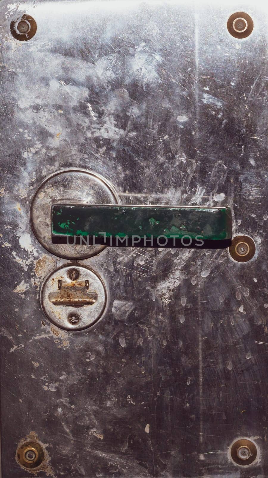 Rusty door handle and keyhole on the metal door. old steel surface. iron surface with doorknob. grunge texture. industrial background