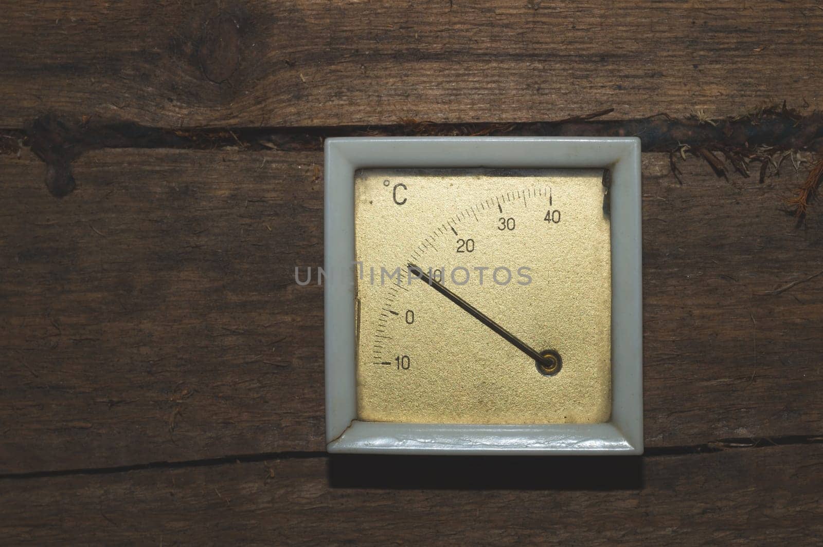 Vintage thermometer hanging on a wooden wall. celsius scale with degrees. indoor temperature measurement