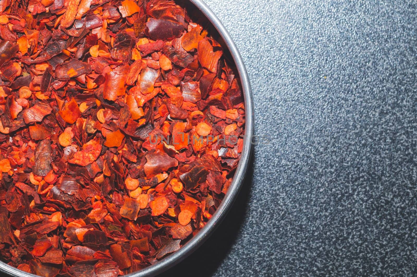 Dried chili pepper in the jar. hot spice. red seasoning background. copy space